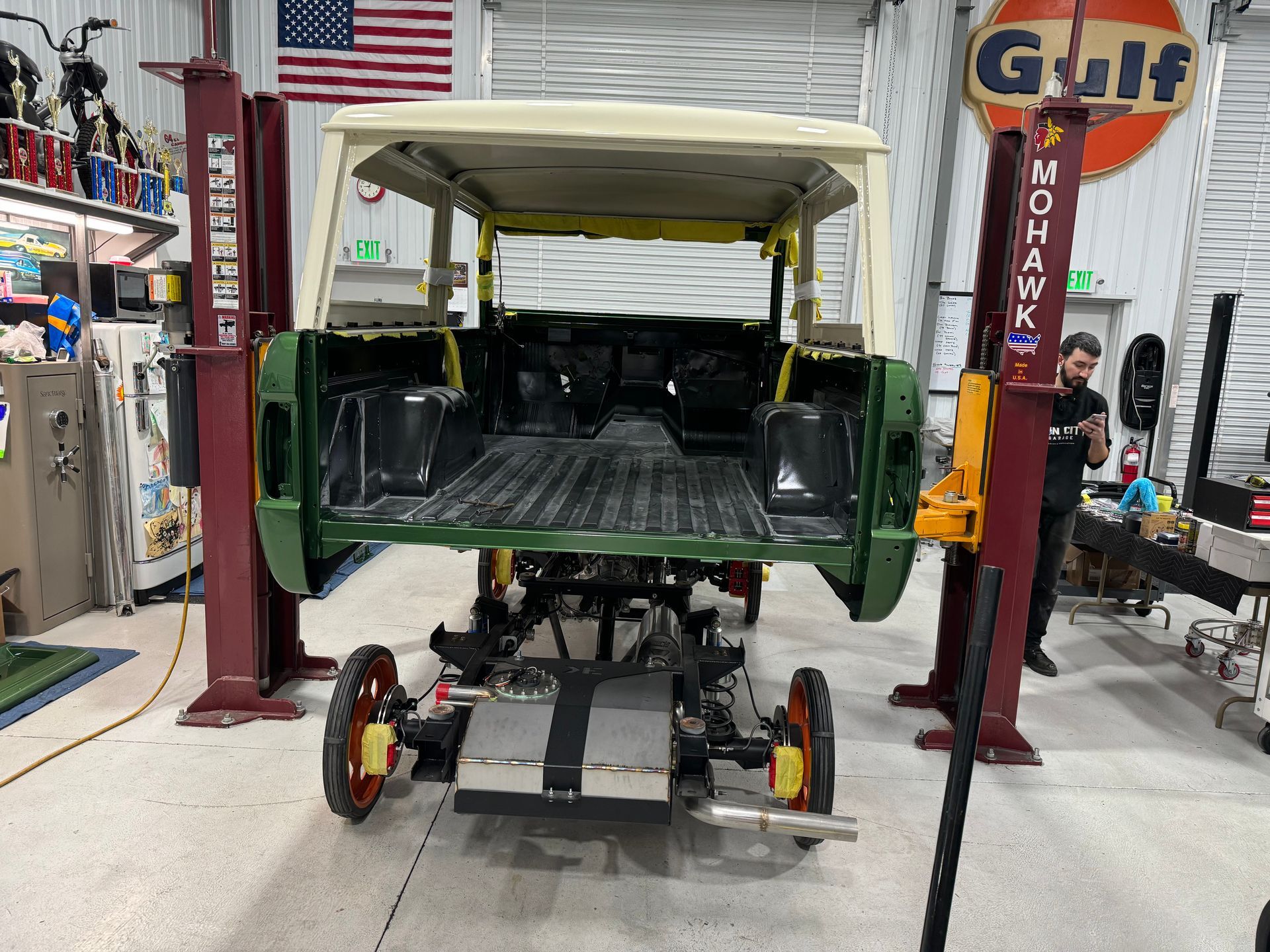 A jeep is sitting on a lift in a garage.