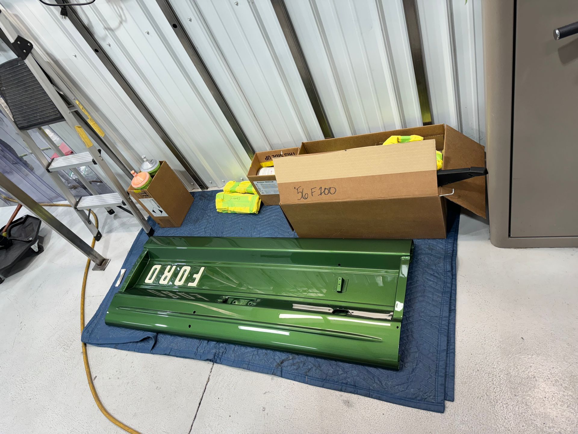 A green ford tailgate is sitting on a blue towel