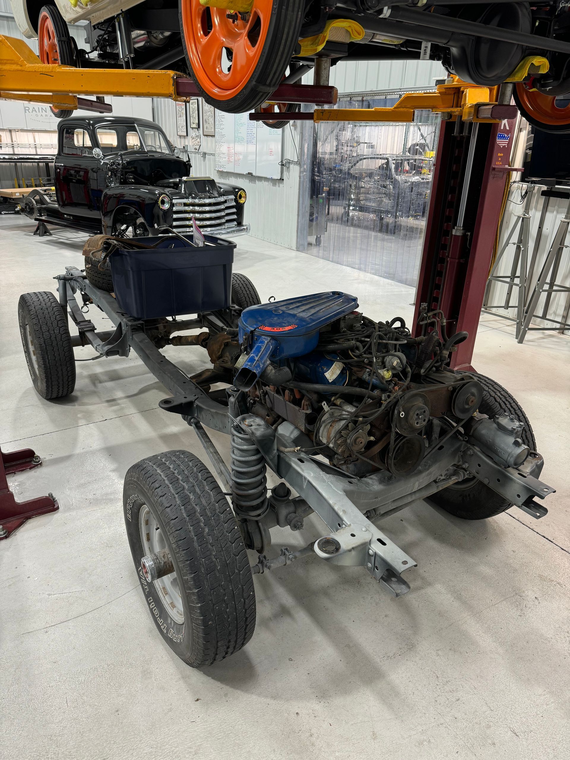 A car is being built on a lift in a garage.