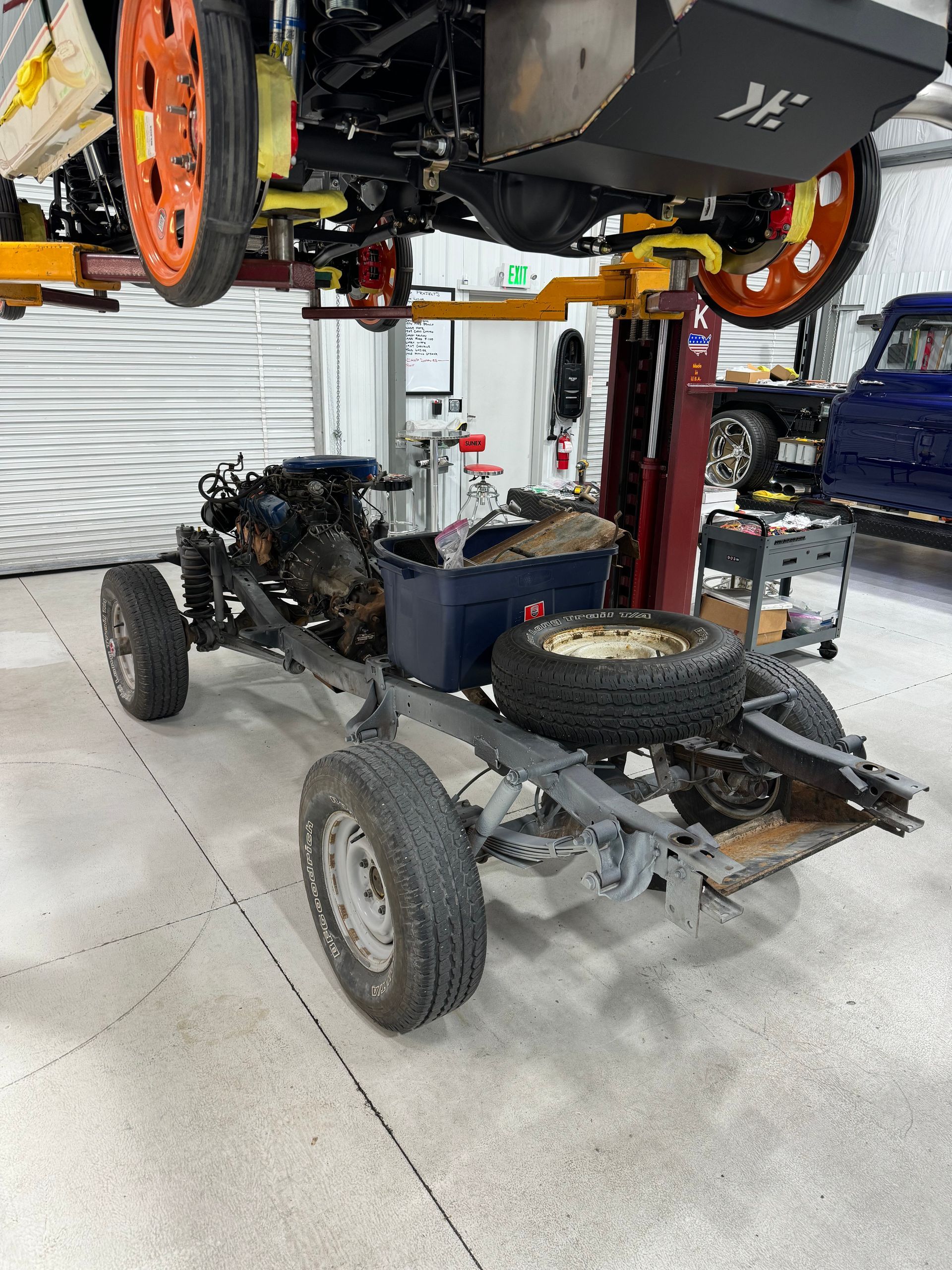 A car is sitting on a lift in a garage.