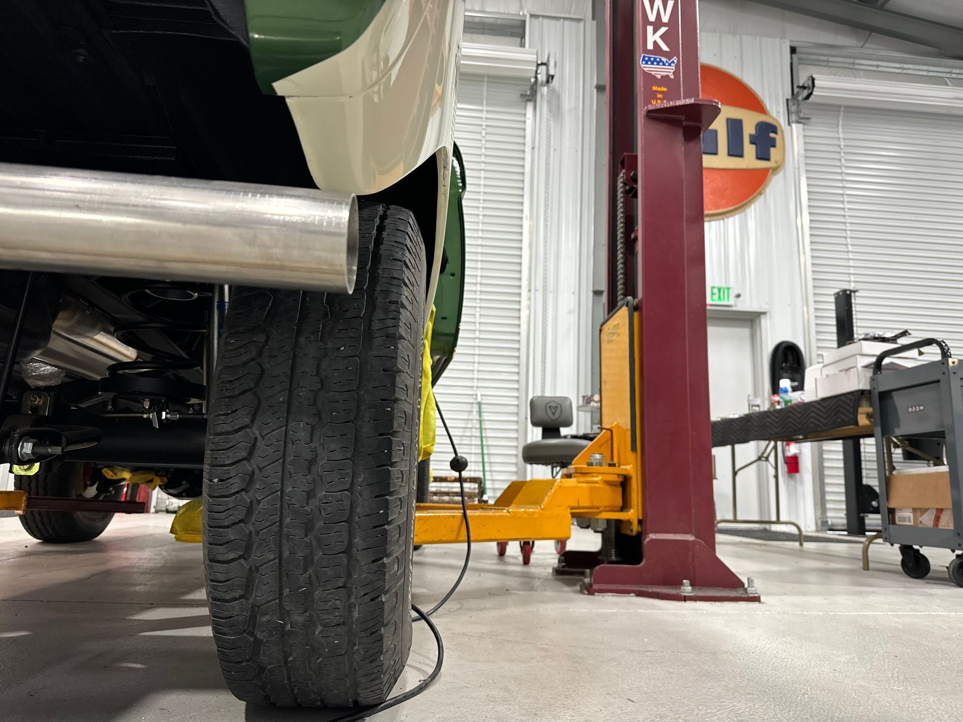 A car is sitting on a lift in a garage.
