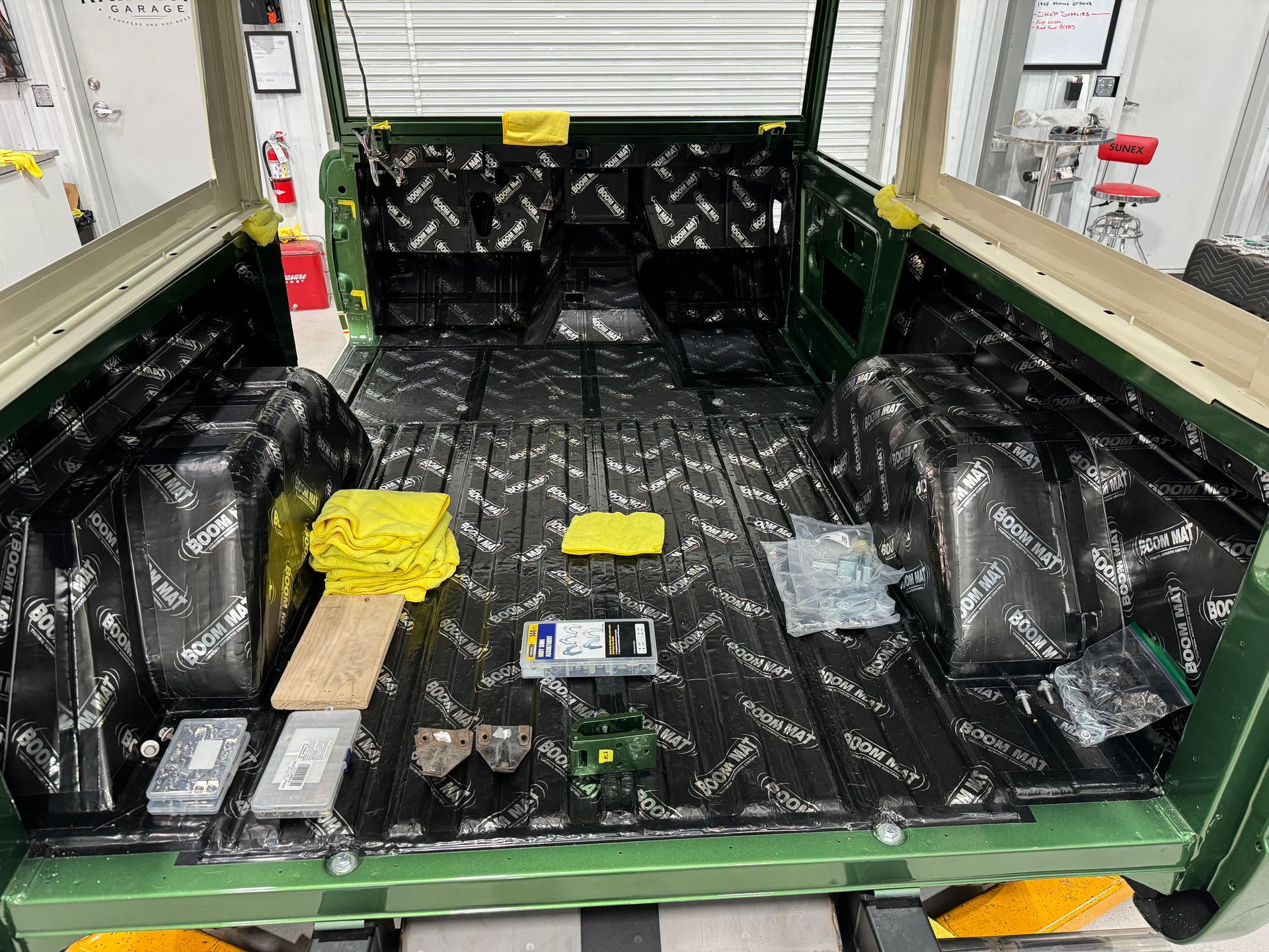 The back of a green land rover is being remodeled.