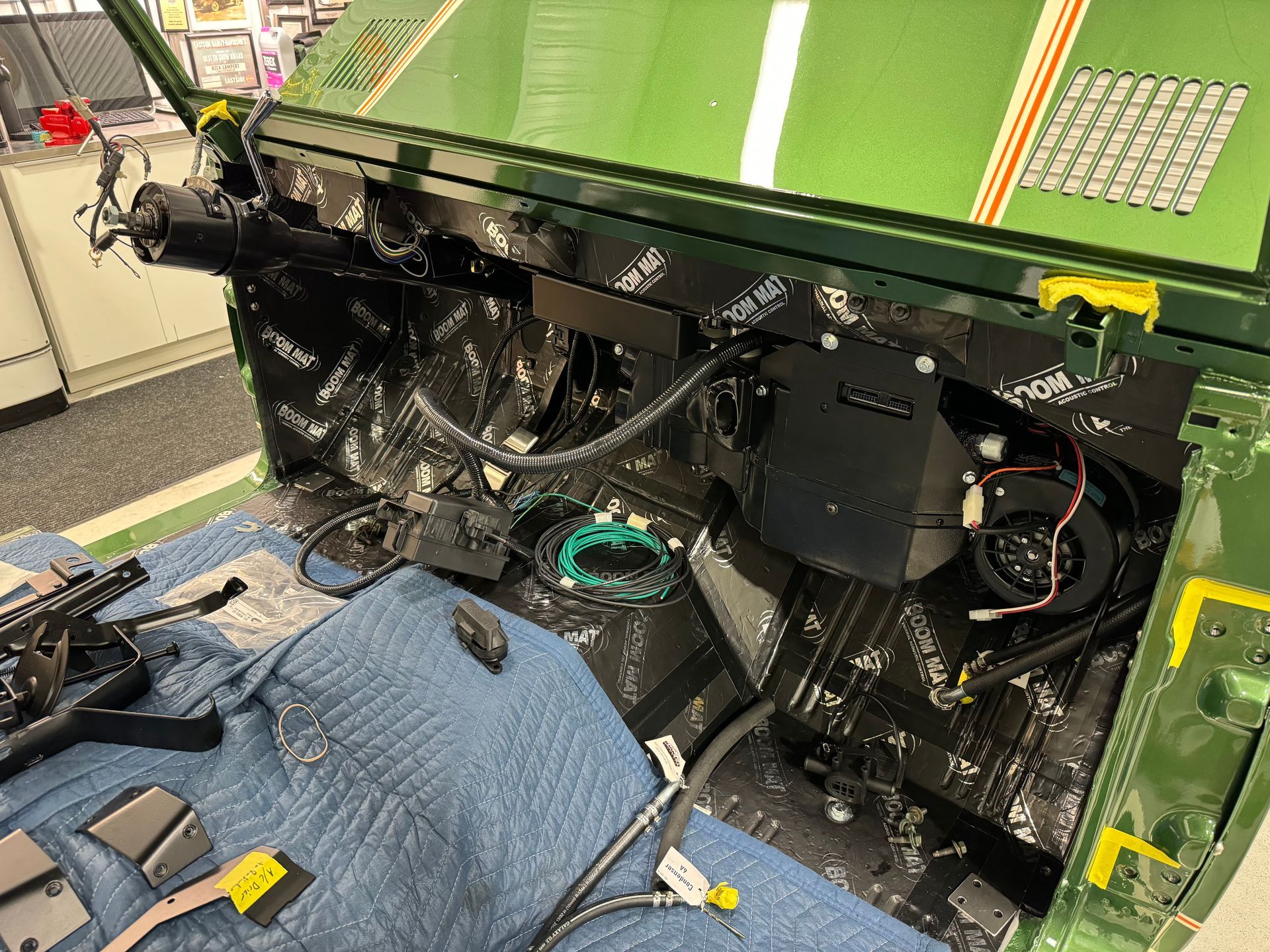 The inside of a green car is being worked on.