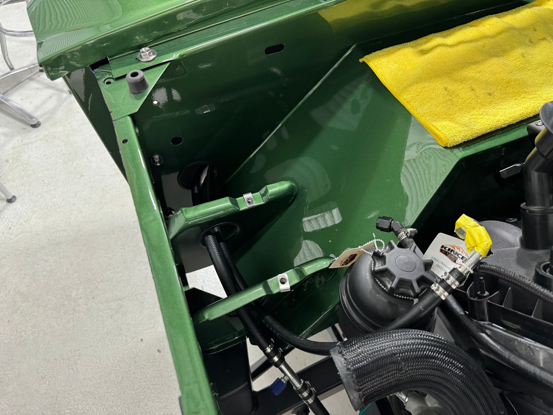 A green car with a yellow towel on top of it.