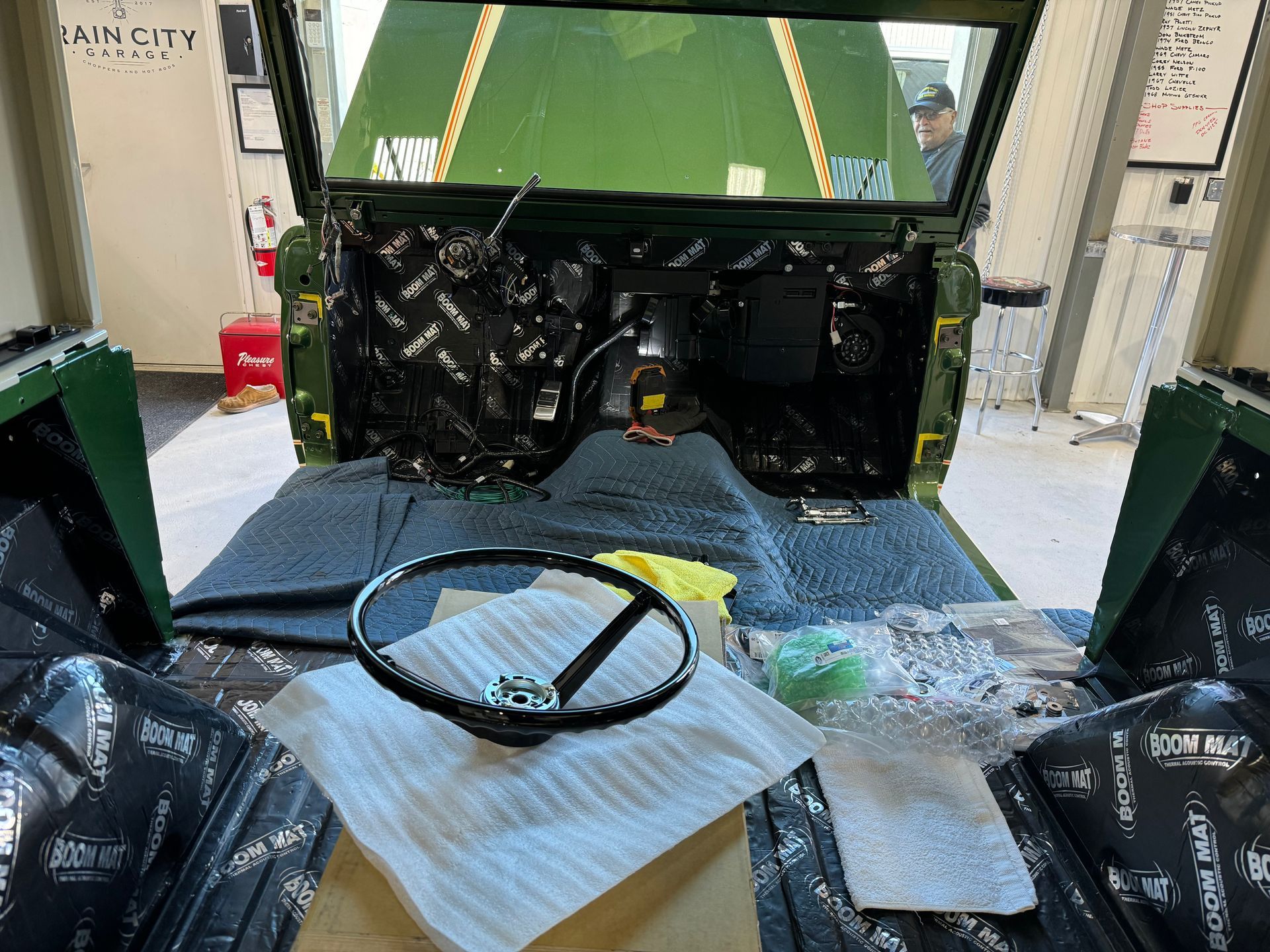 A steering wheel is sitting on top of a piece of paper in the cockpit of a military vehicle.