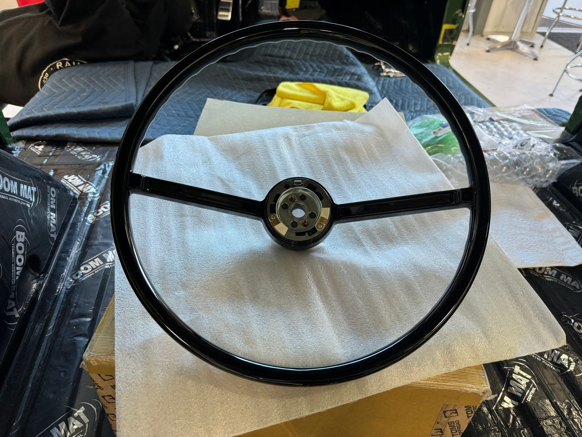 A black steering wheel is sitting on top of a piece of foam.