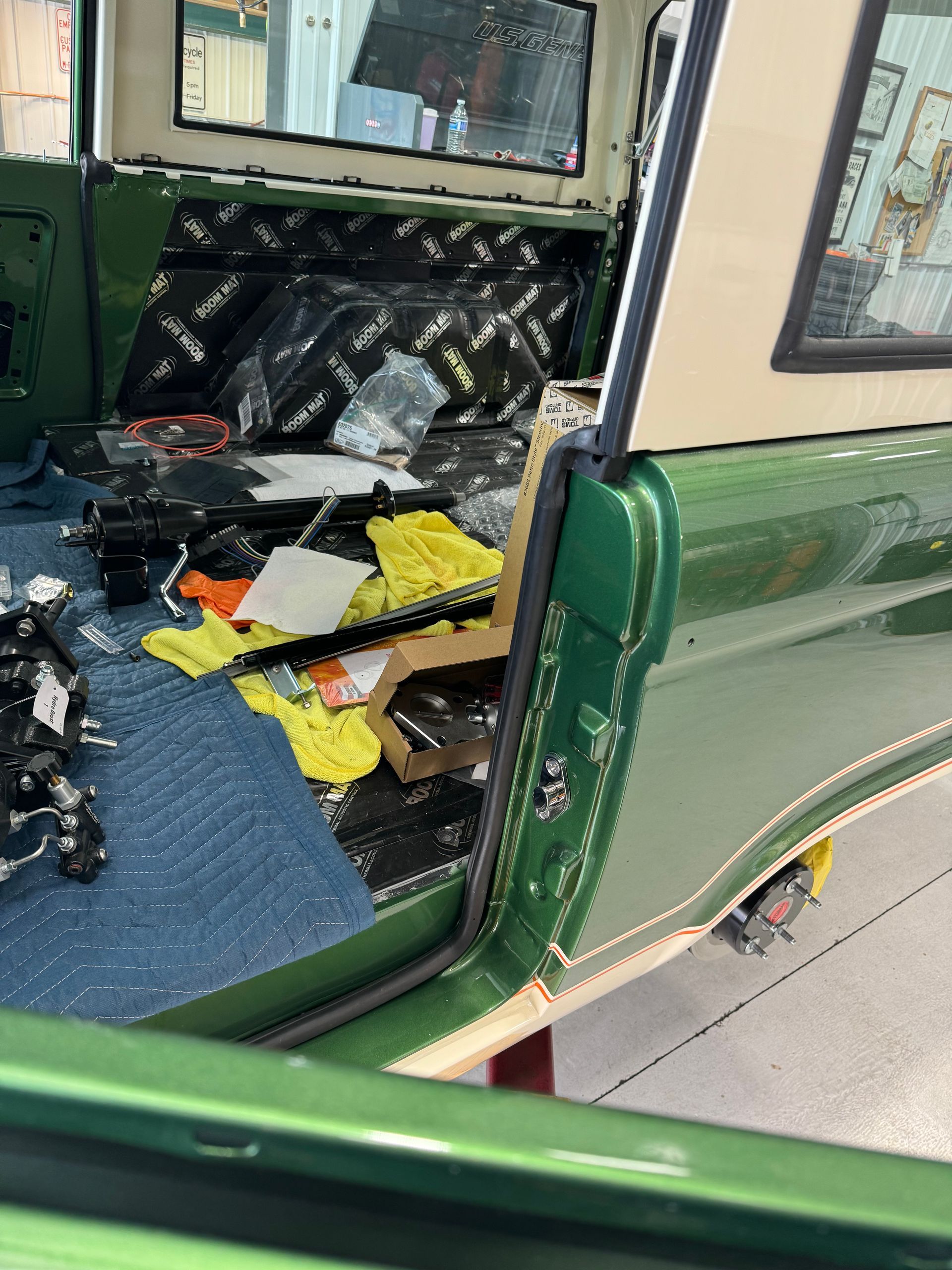 The back of a green truck is being worked on.