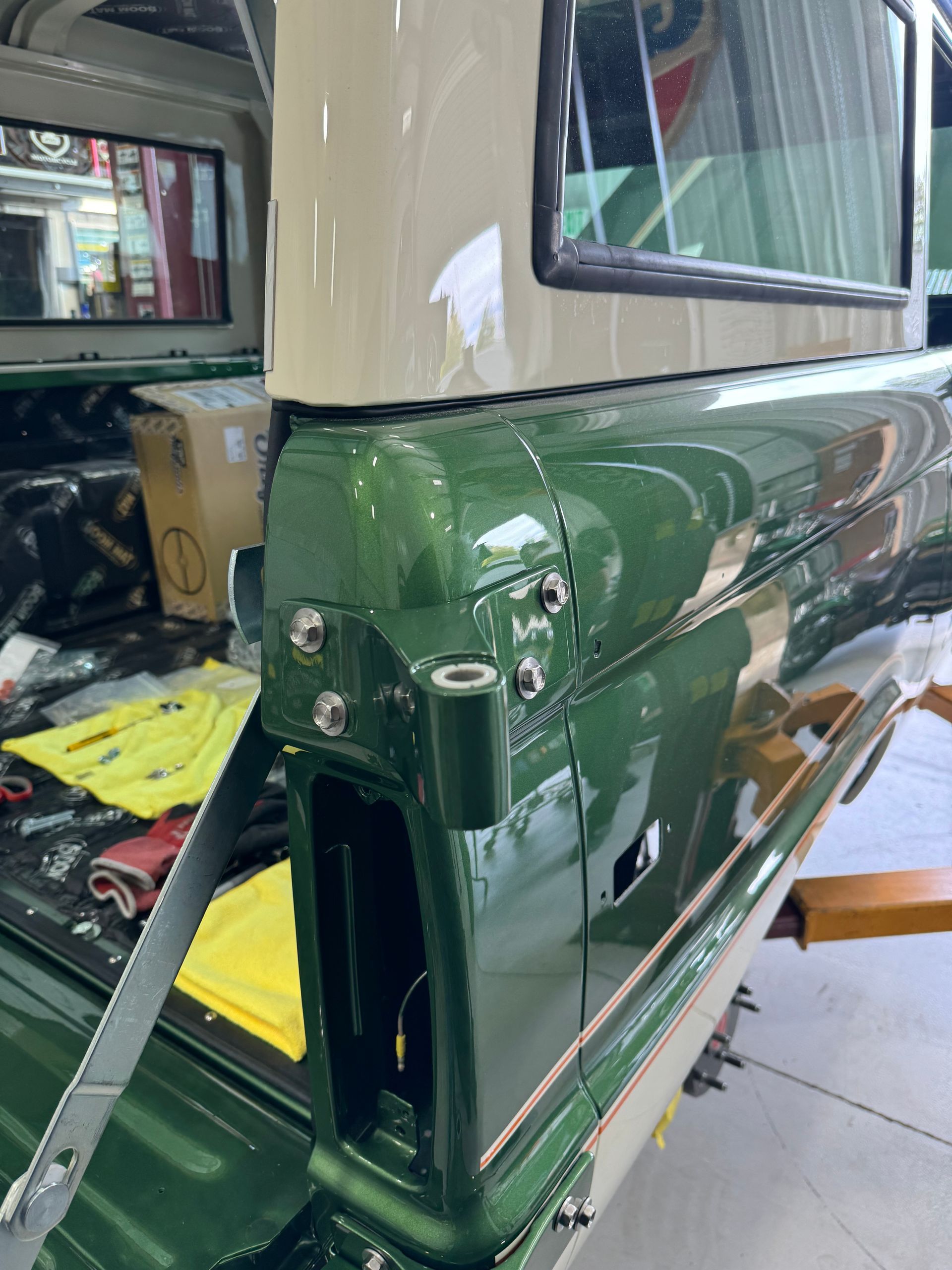 A green and white truck is being built in a garage