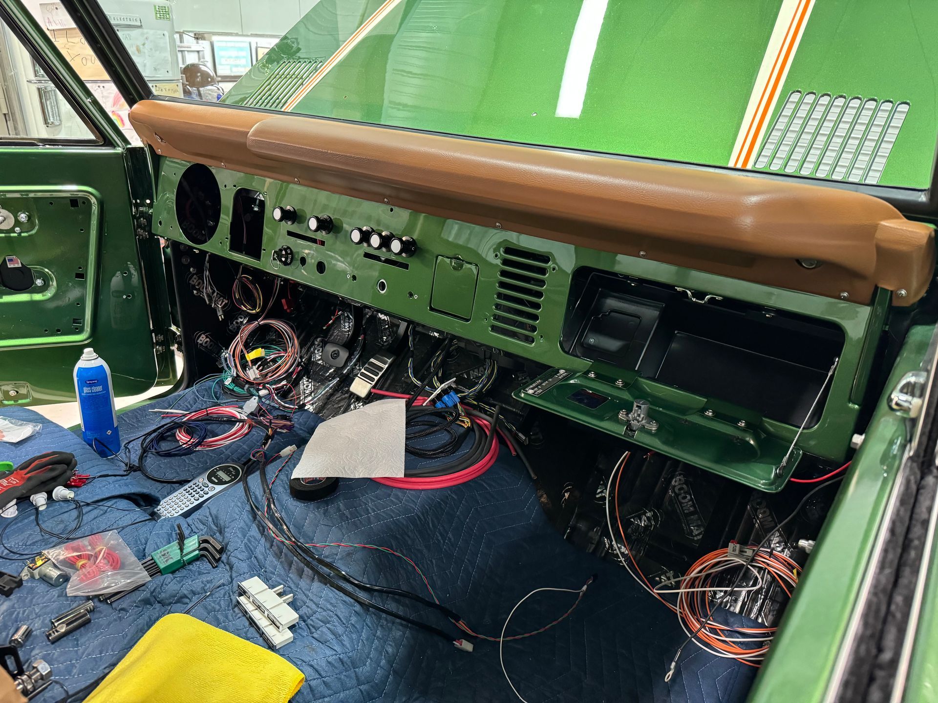 The dashboard of a green car is being worked on.