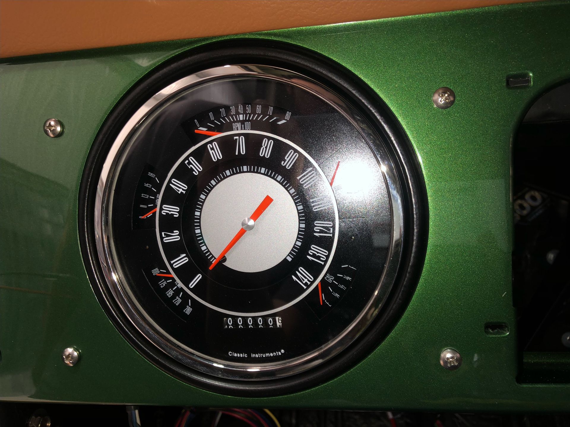 A close up of a speedometer on a green car