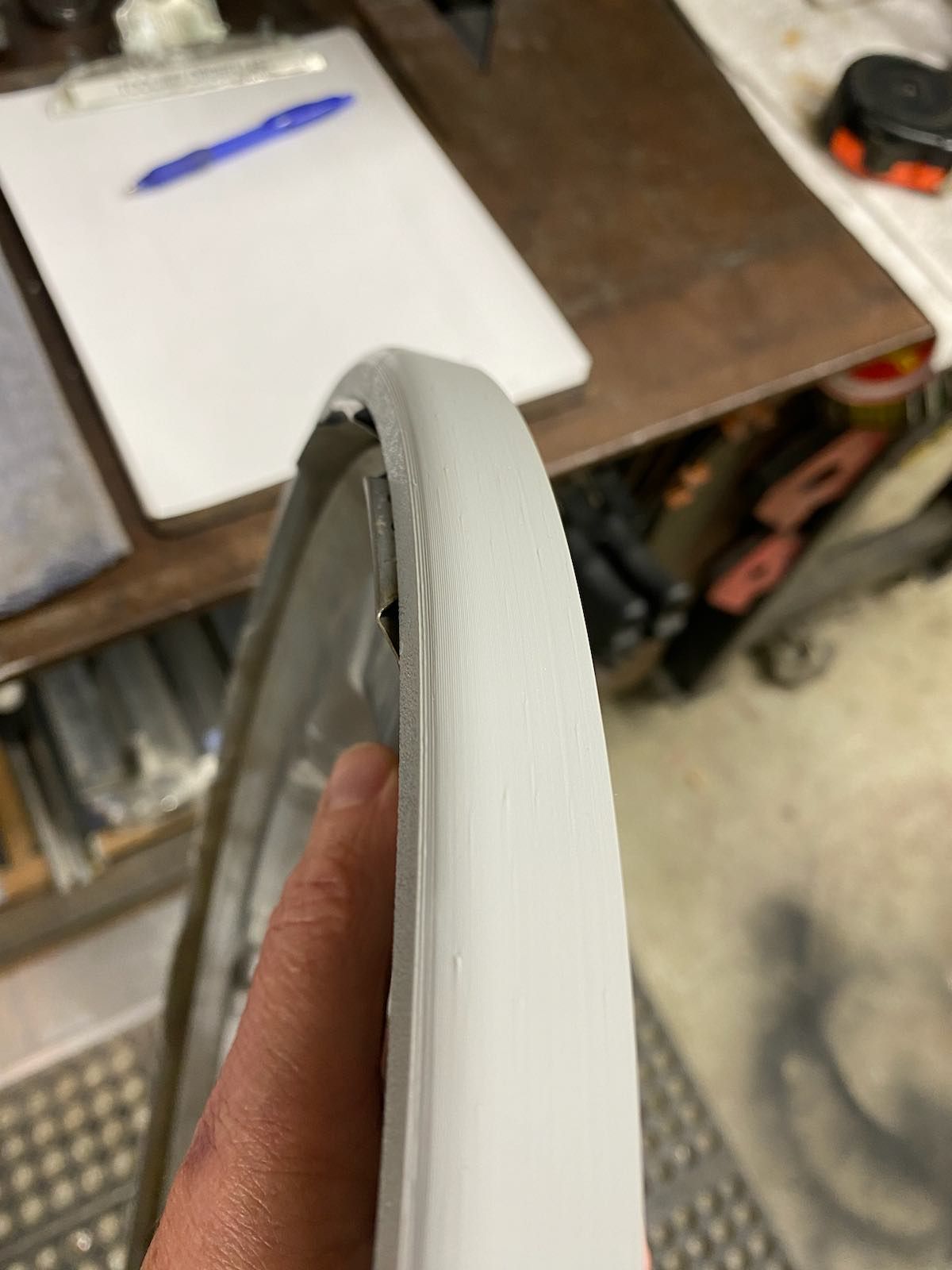 A person is holding a white tire in their hand.