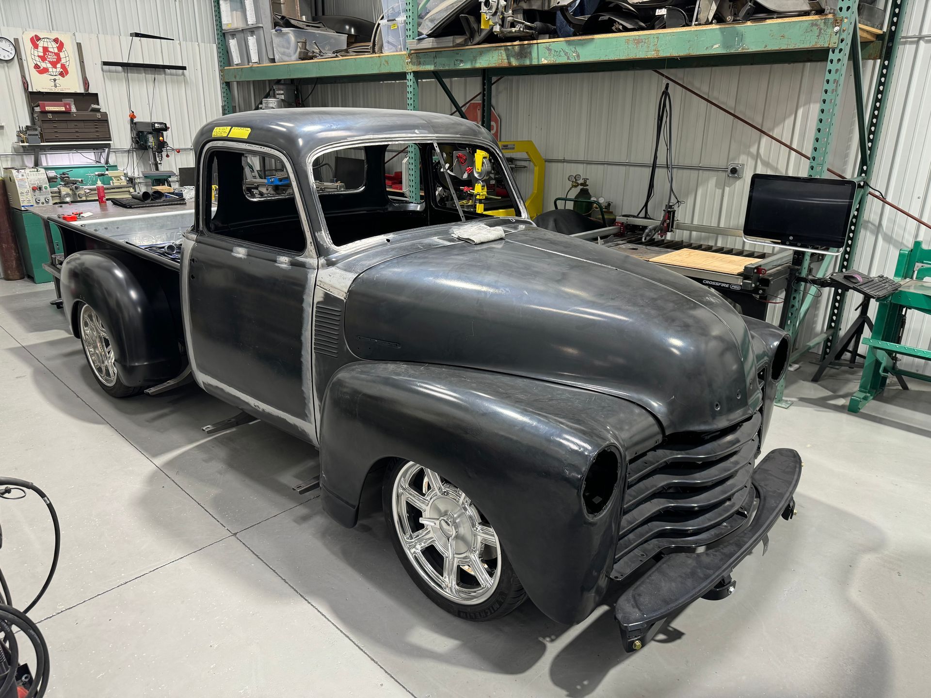 An old pickup truck is sitting in a garage.