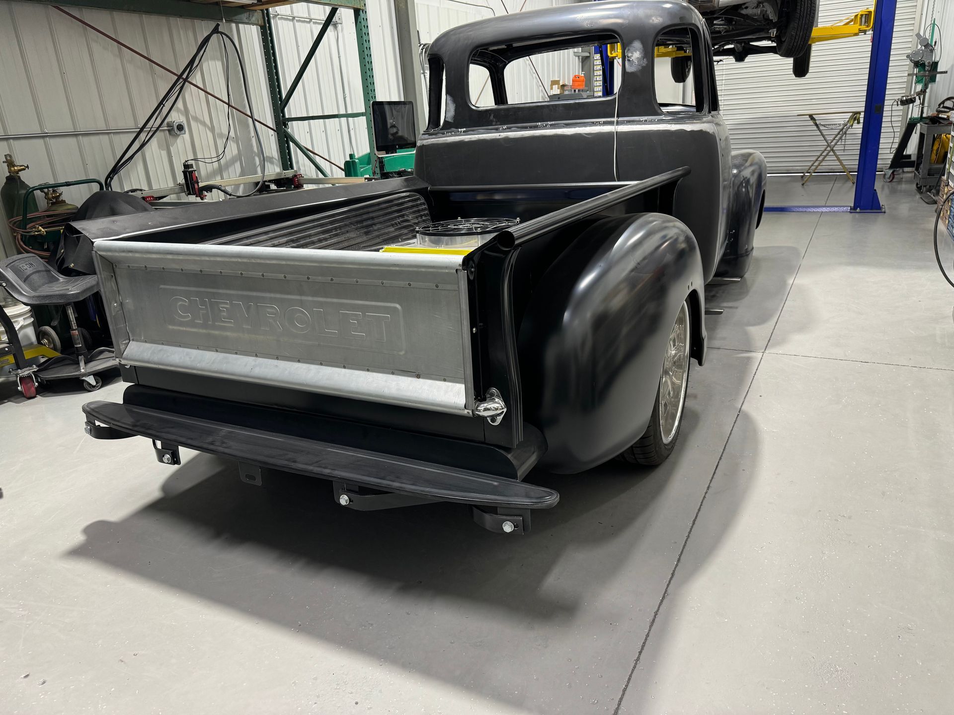 A black pickup truck is parked in a garage.