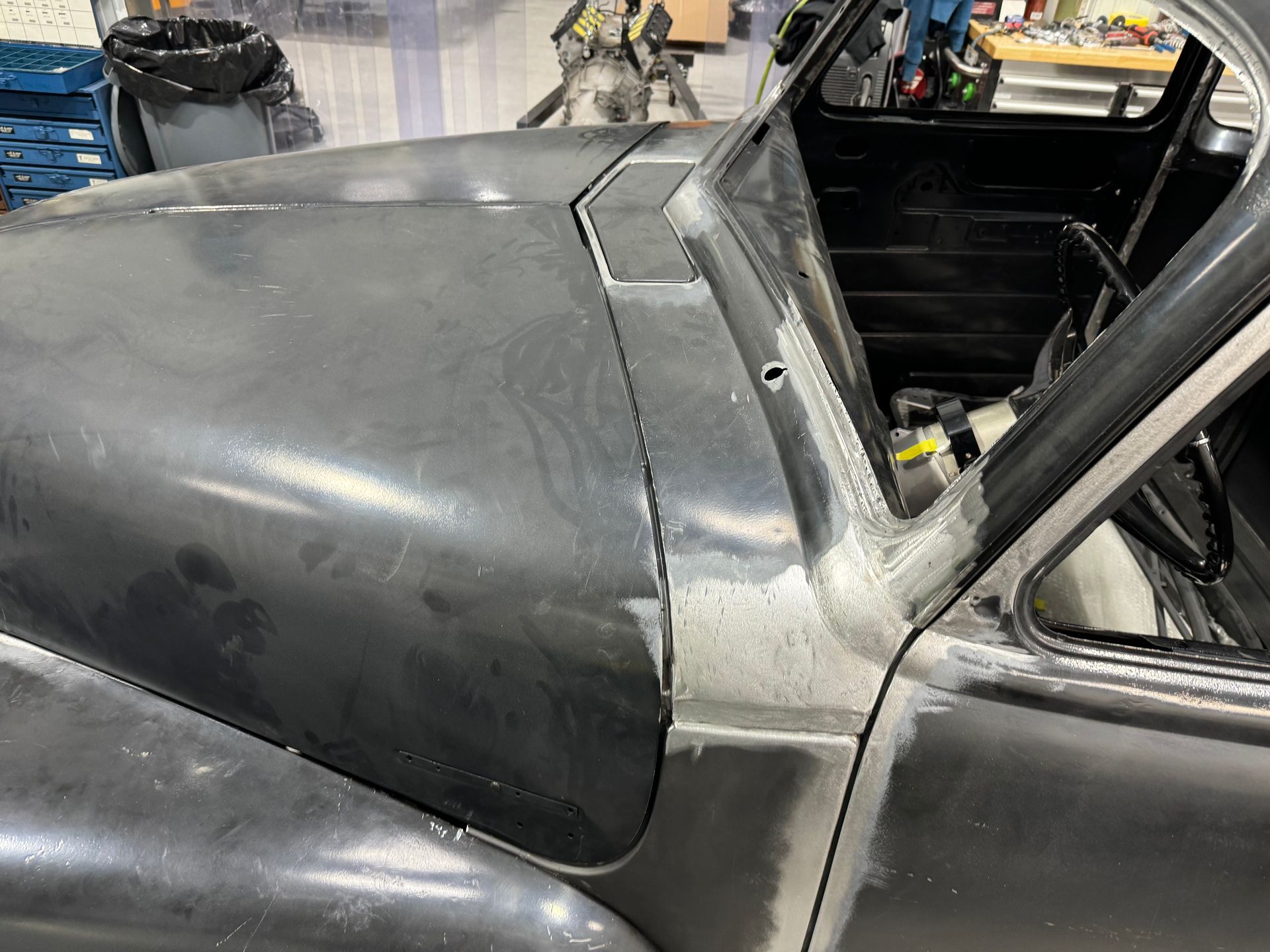 A close up of the hood of a car in a garage.