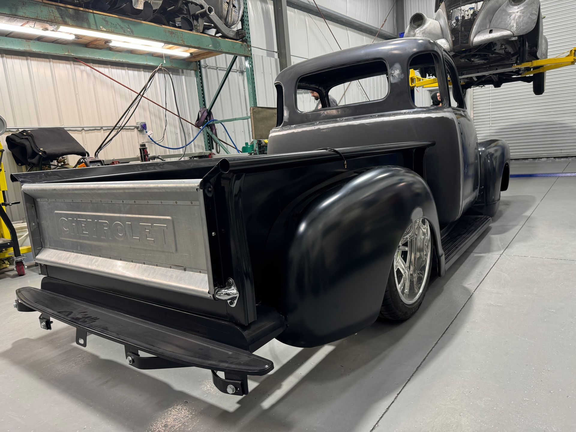 A black pickup truck is parked in a garage.