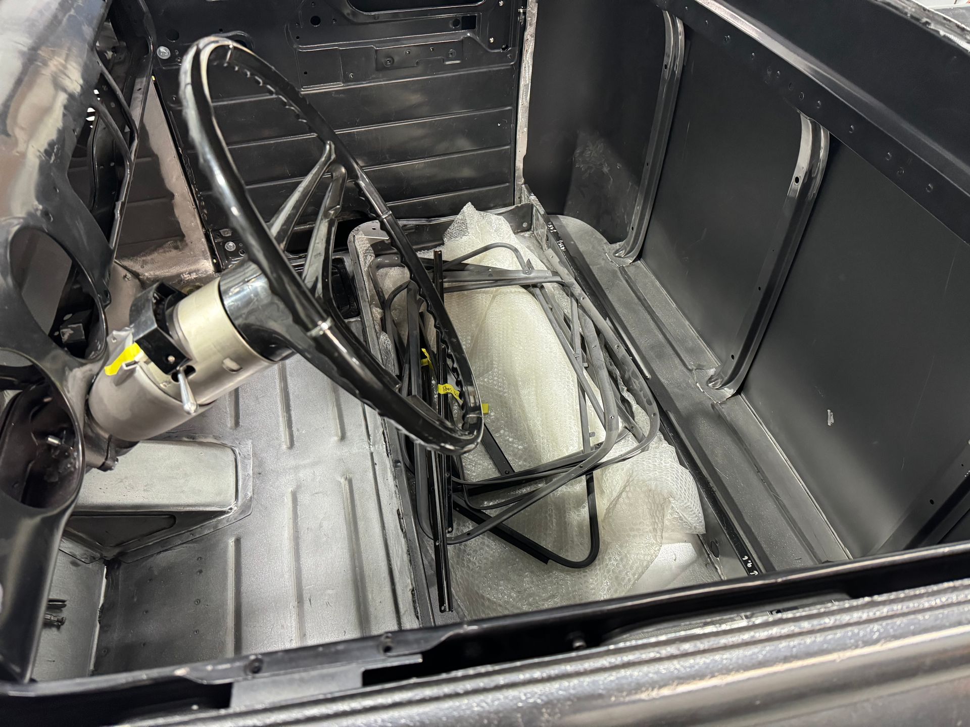 The inside of a car with a steering wheel and a seat.