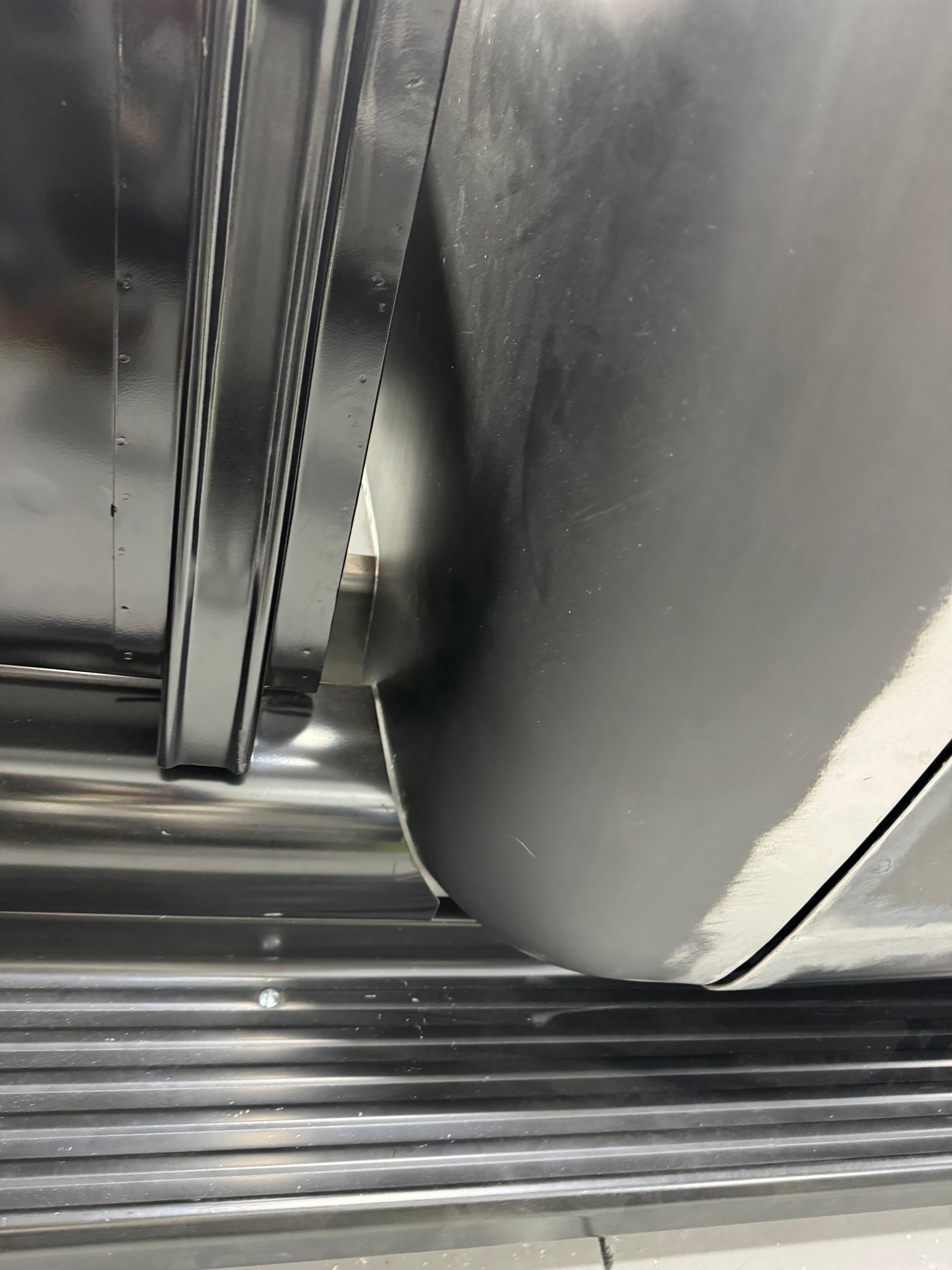 A close up of a stainless steel door with a hole in it.