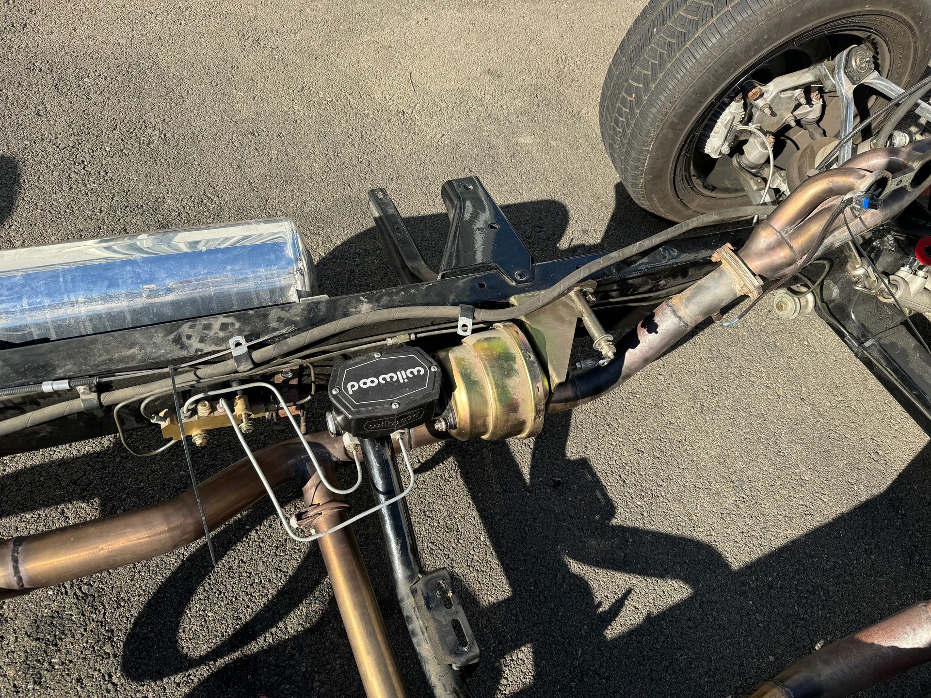 A close up of a car 's exhaust pipe on the ground.