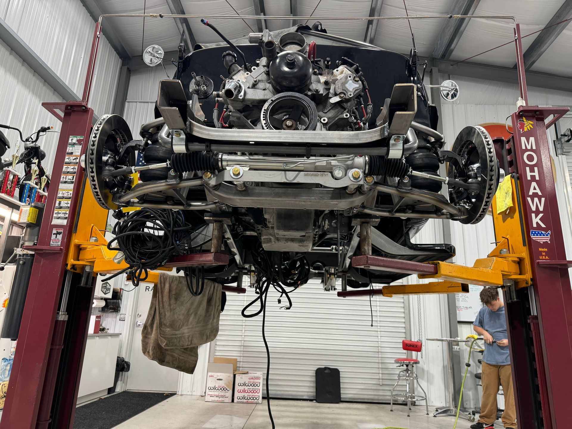 A car is sitting on a lift in a garage.