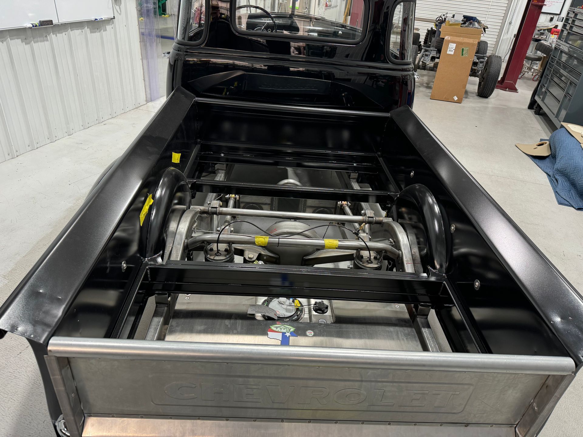 A black truck is being built in a garage.