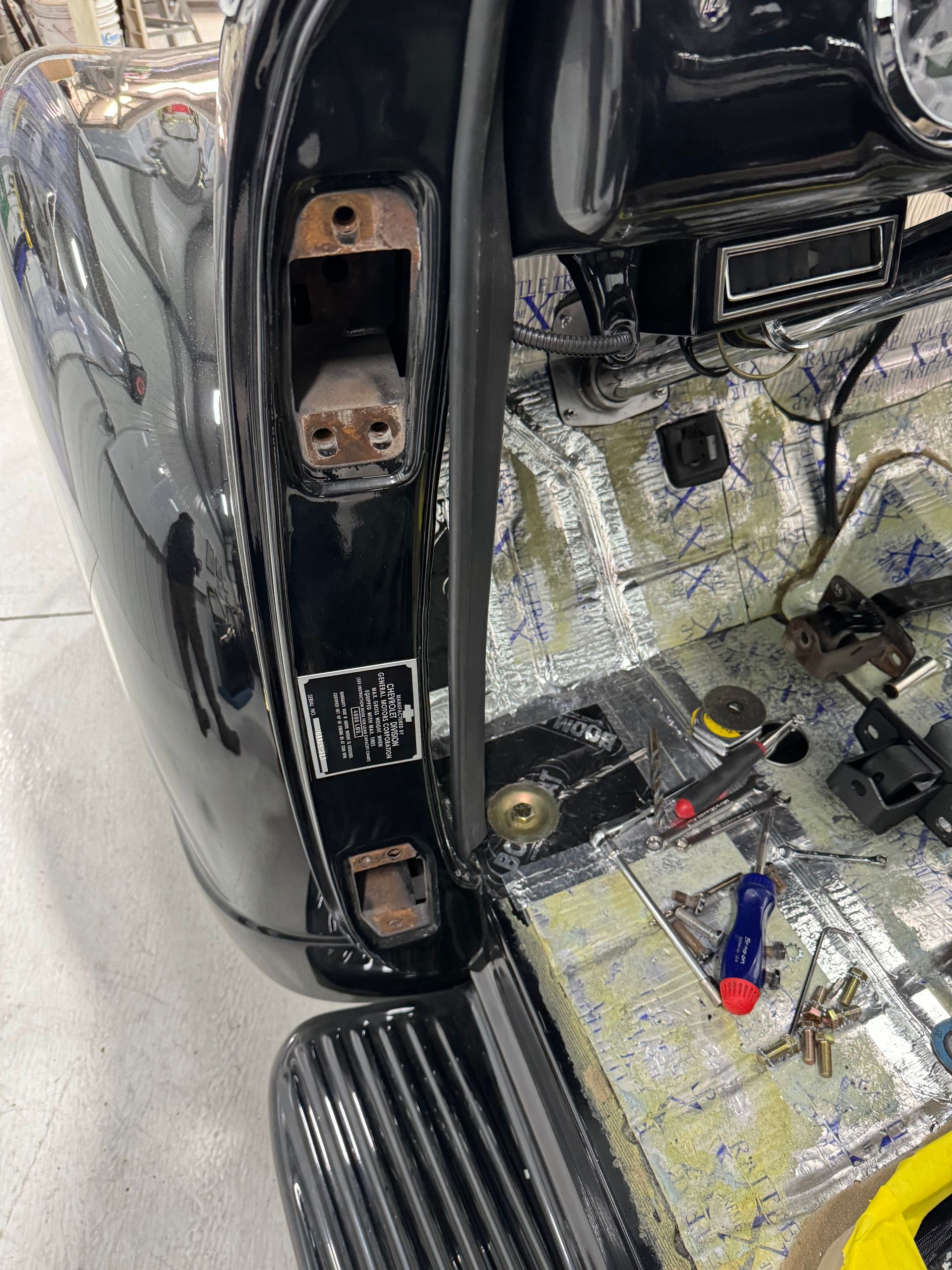 A black car is being worked on in a garage.