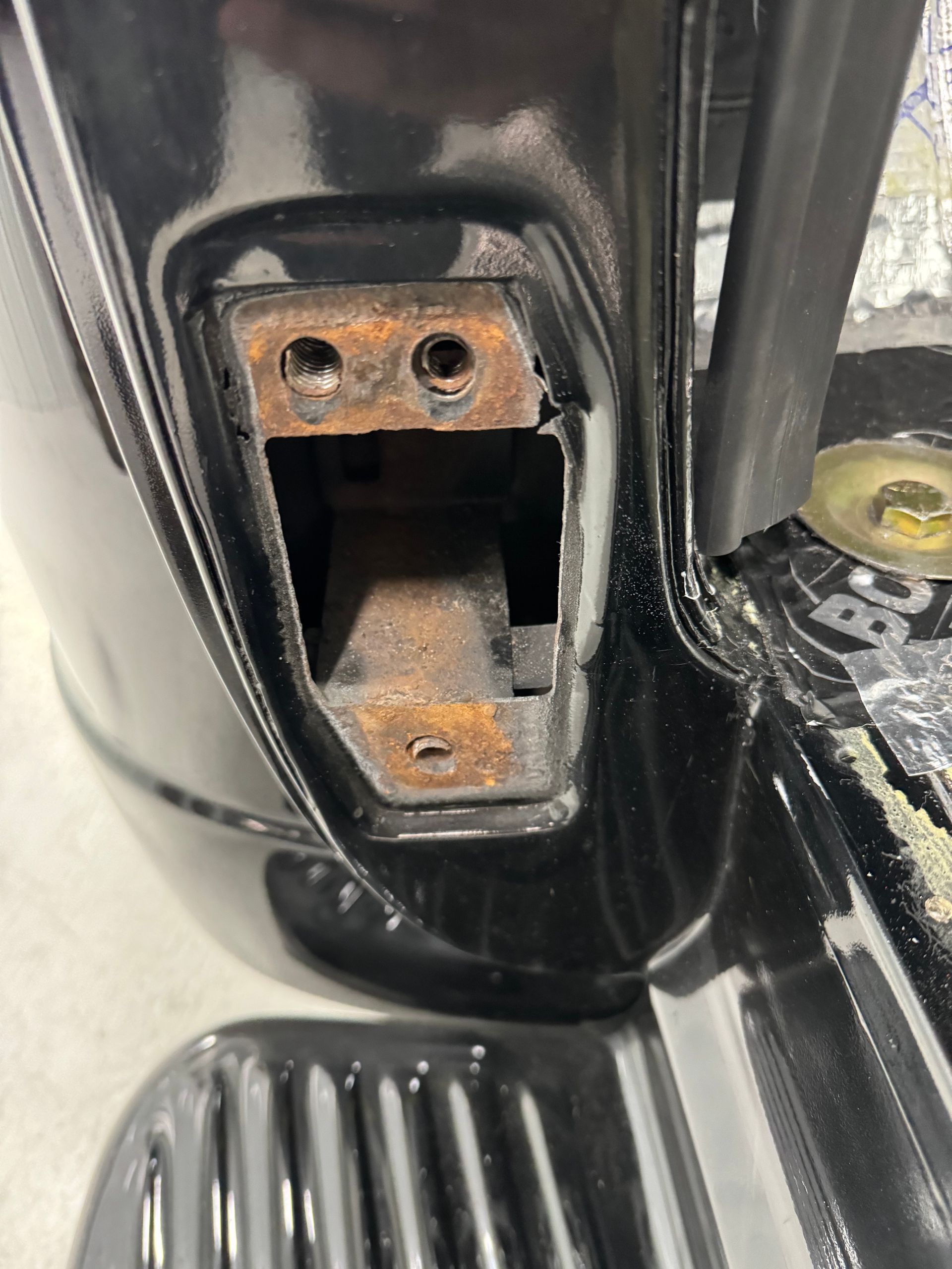 A close up of a rusty piece of metal on a motorcycle.