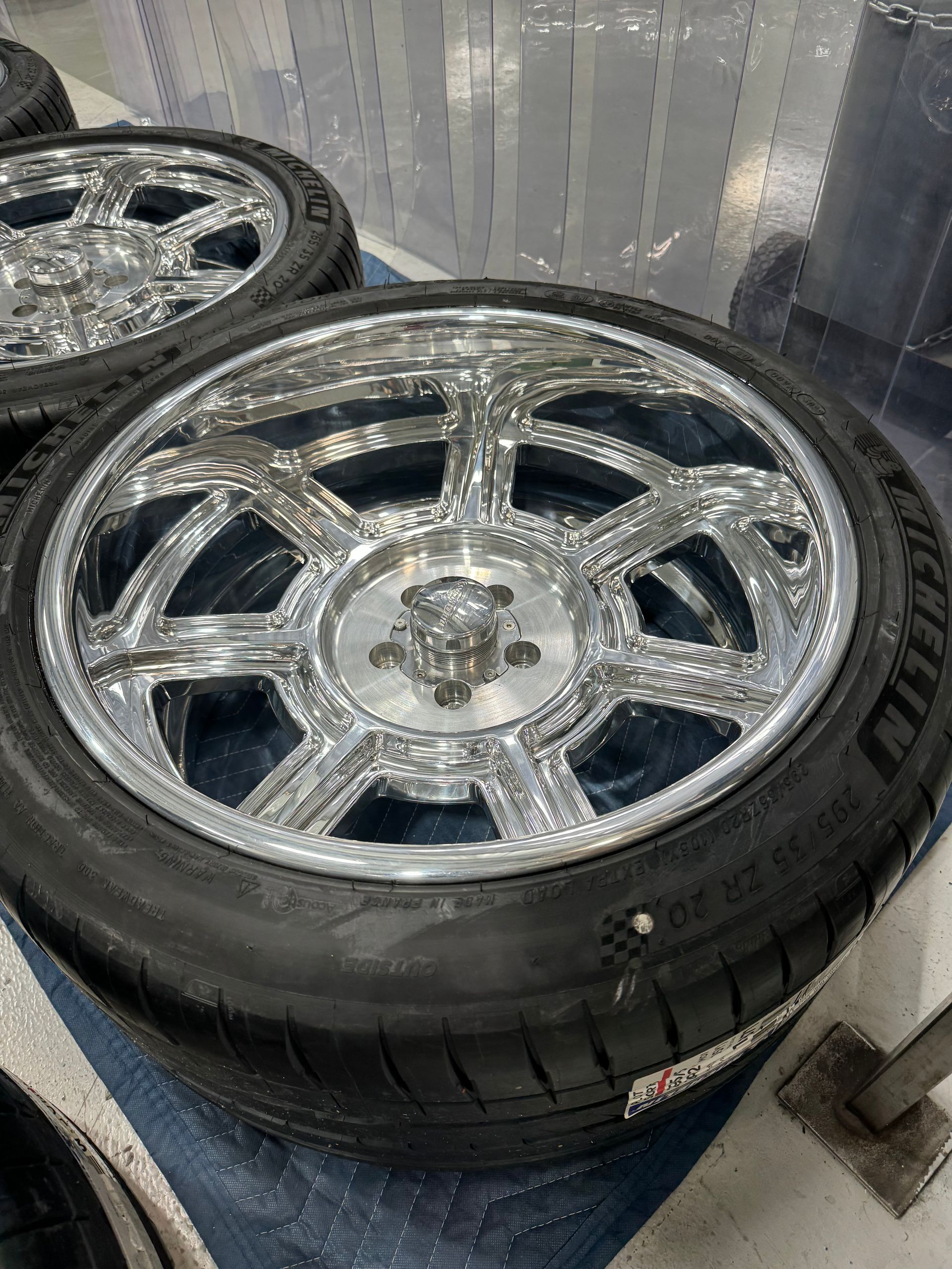 A close up of a chrome wheel and tire on a table.
