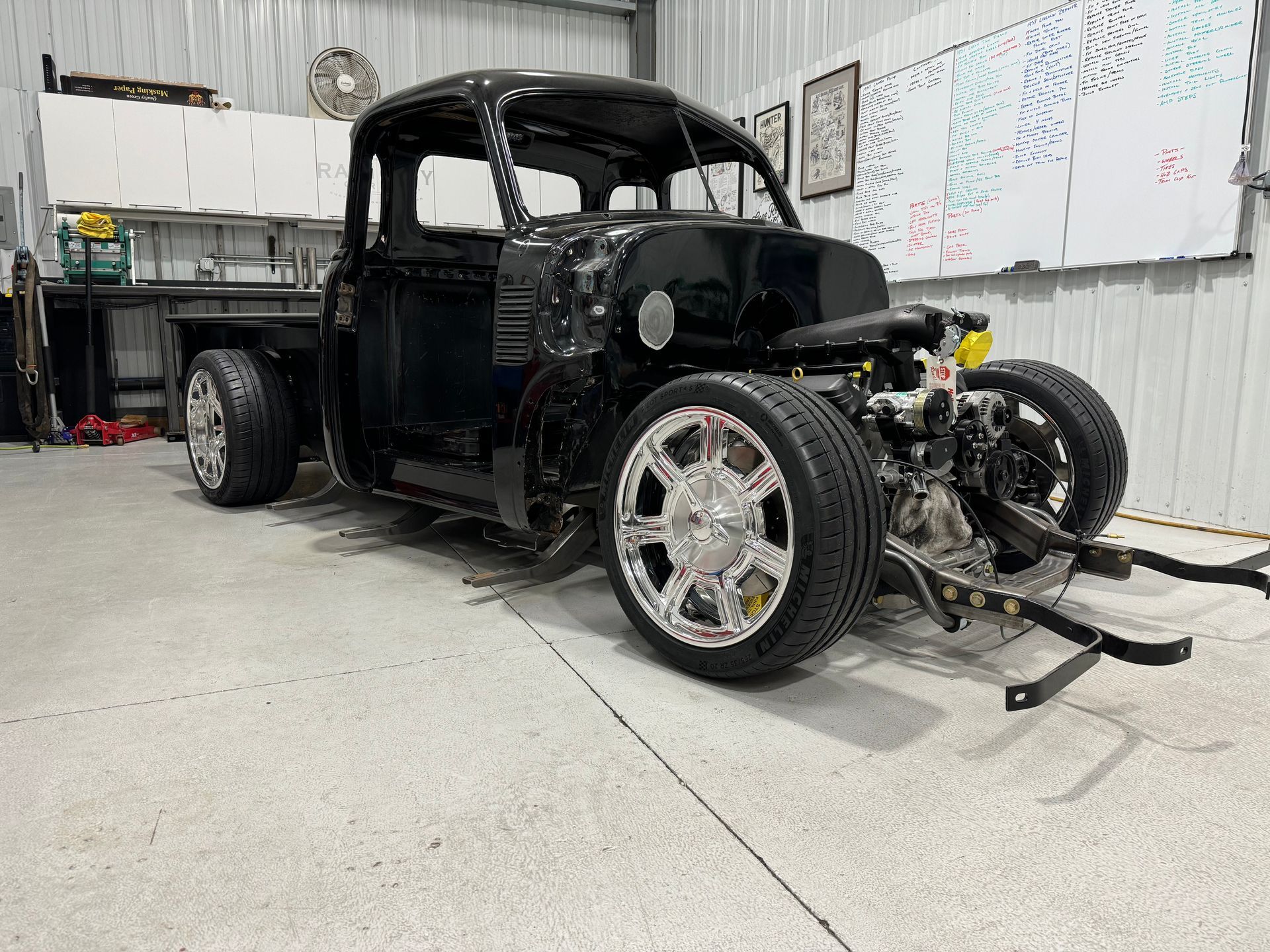 A black truck is being built in a garage.