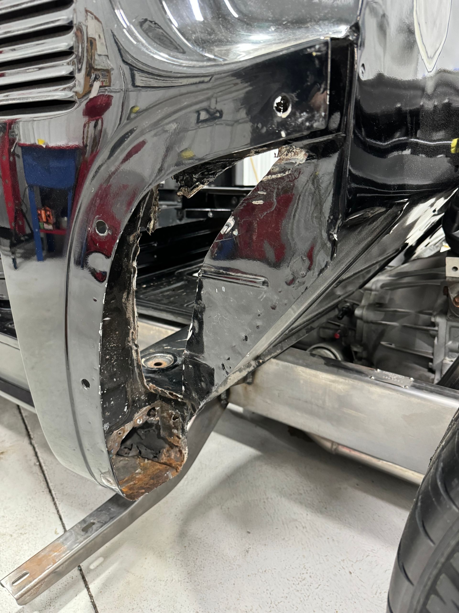 A close up of a car 's front bumper in a garage.