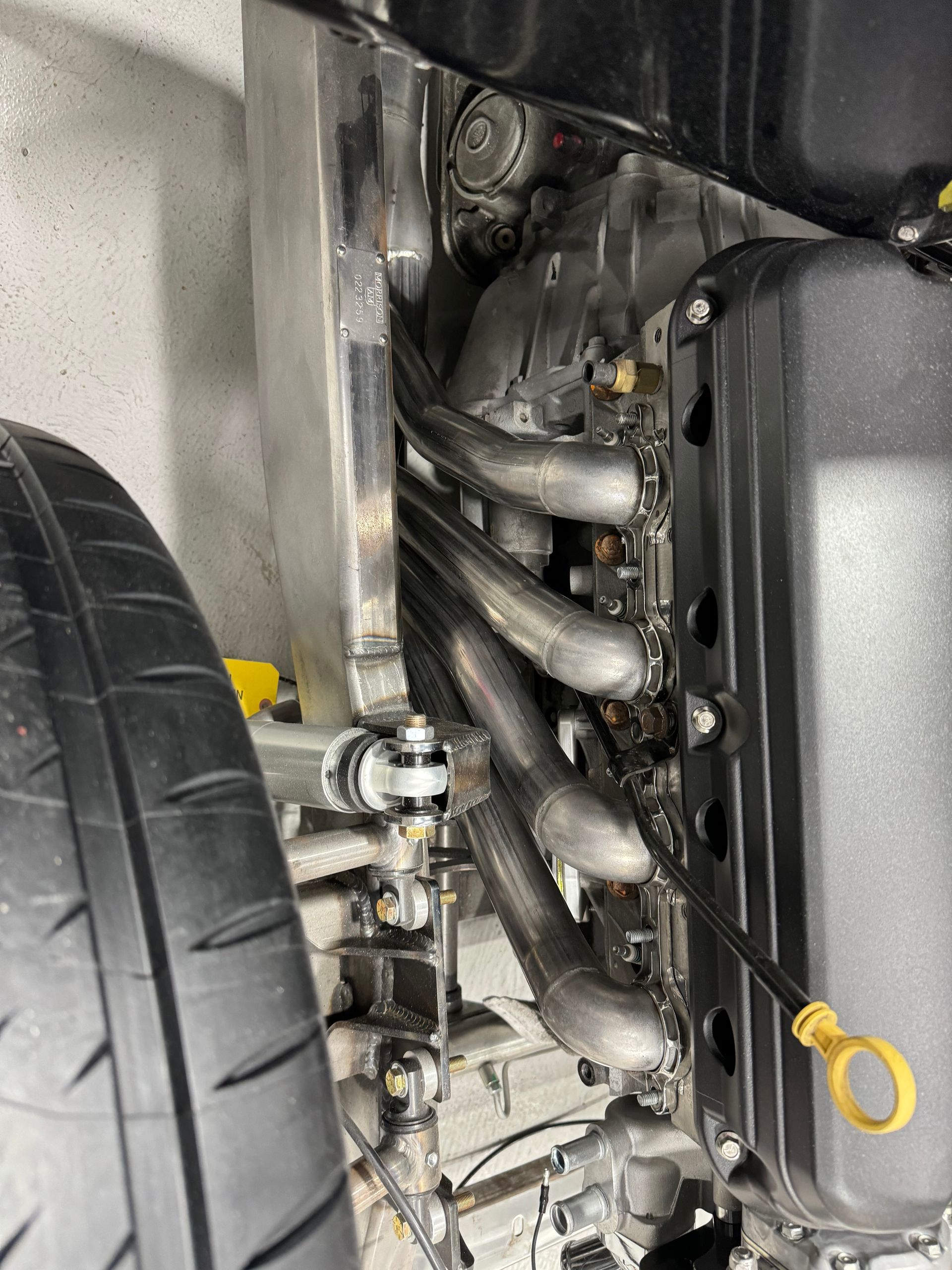 A close up of a car engine with a tire in the background.