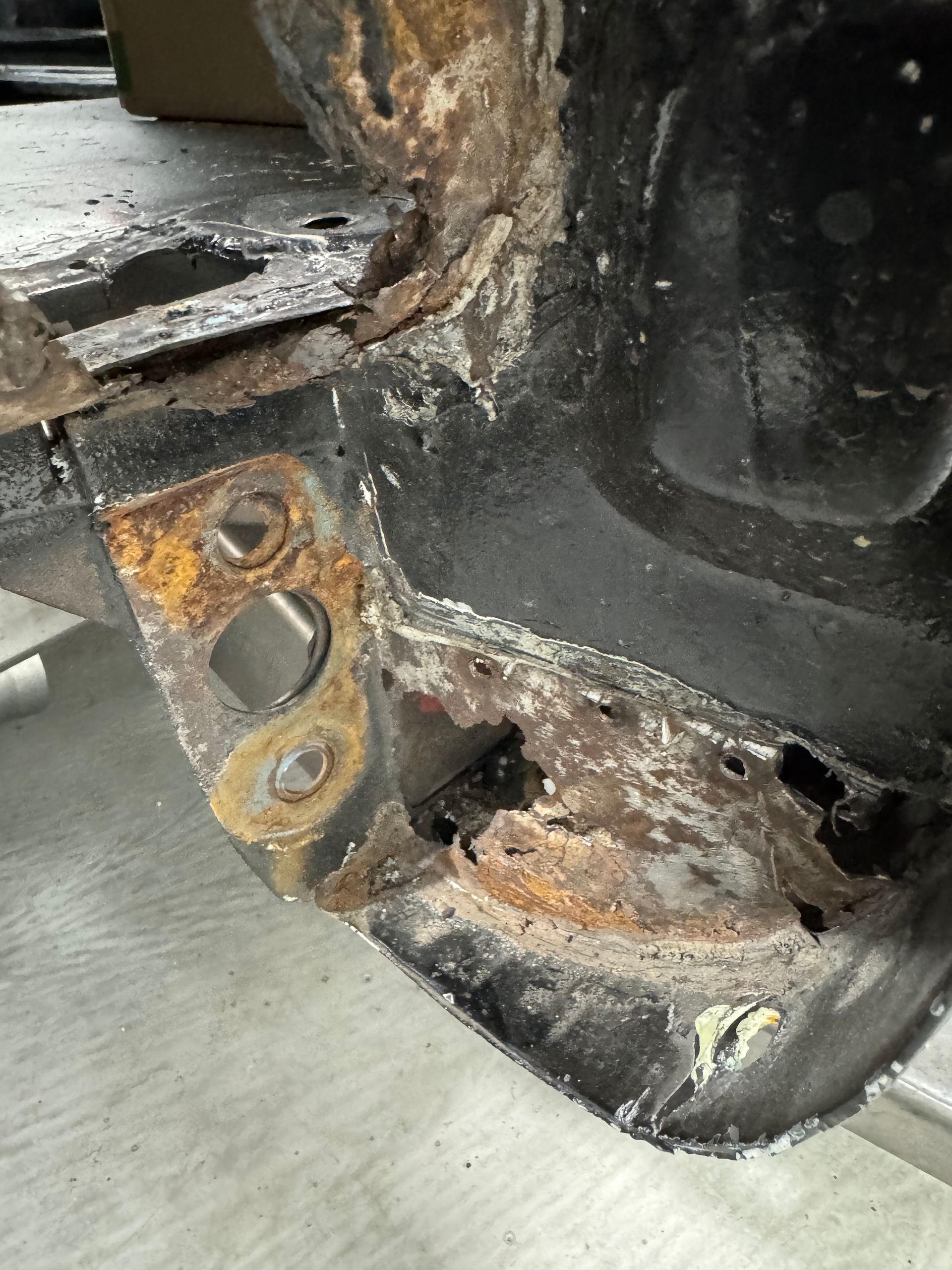 A close up of a rusty piece of metal on a car.