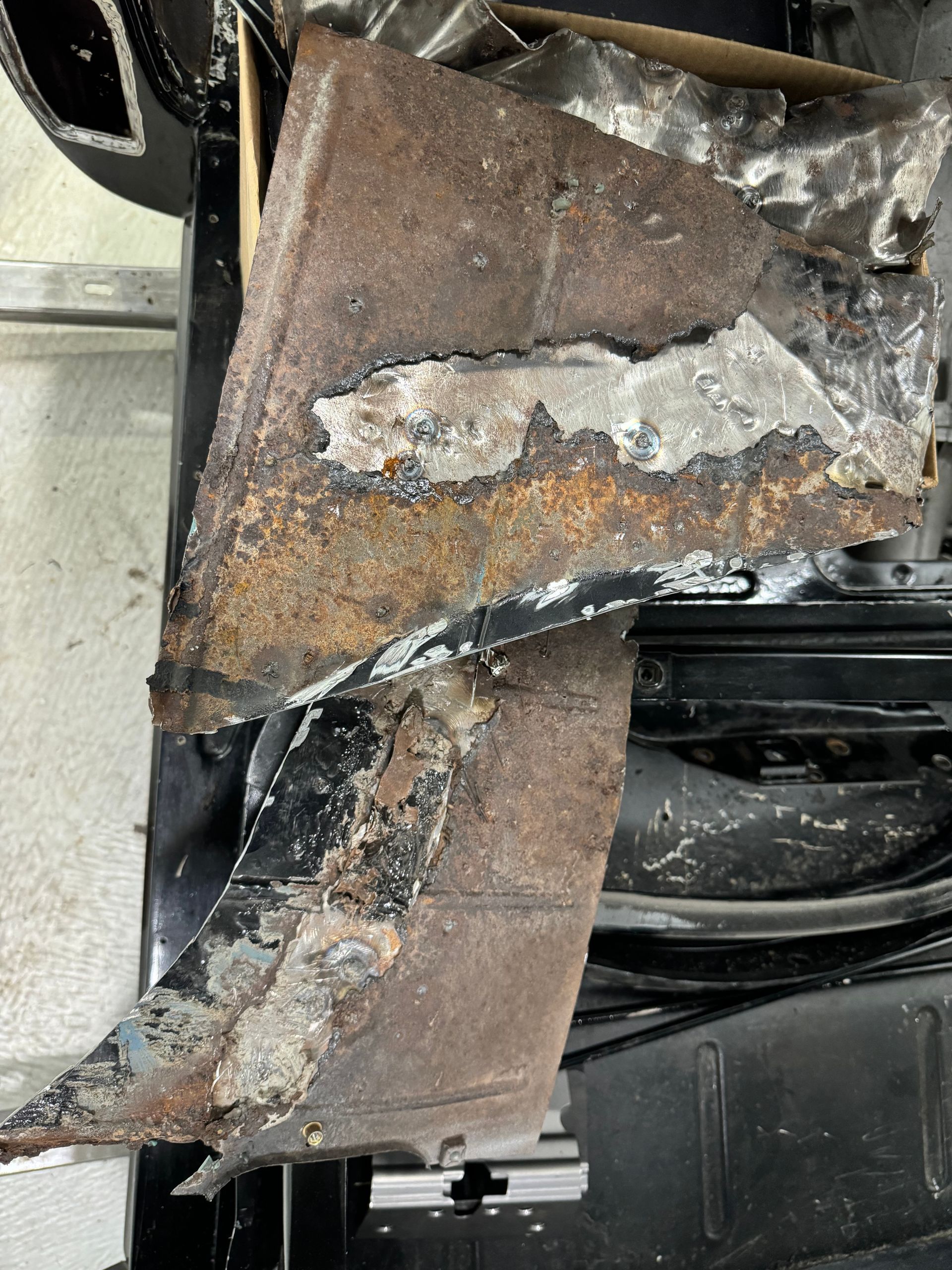 A piece of rusty metal is sitting on top of a car.