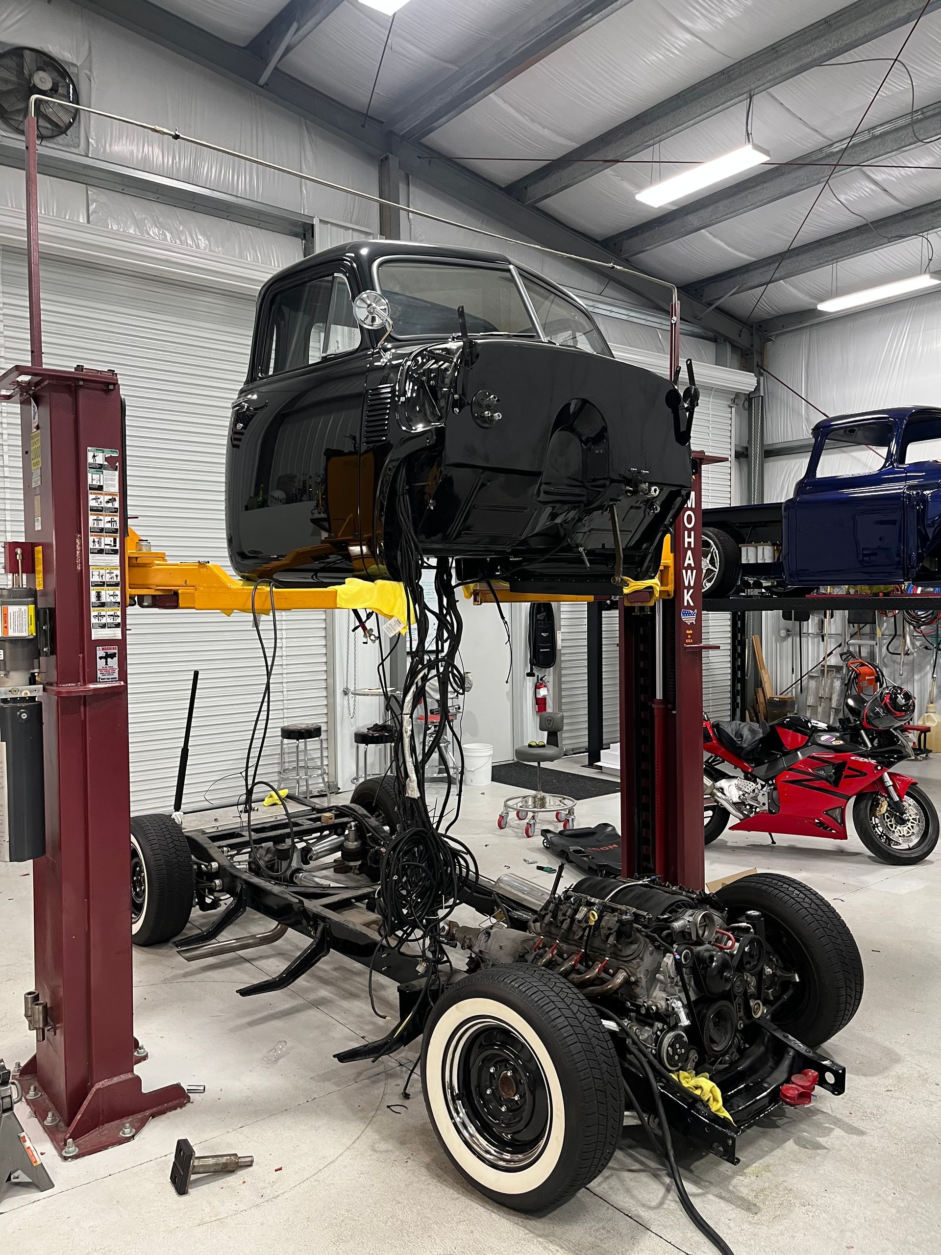A truck is sitting on a lift in a garage.