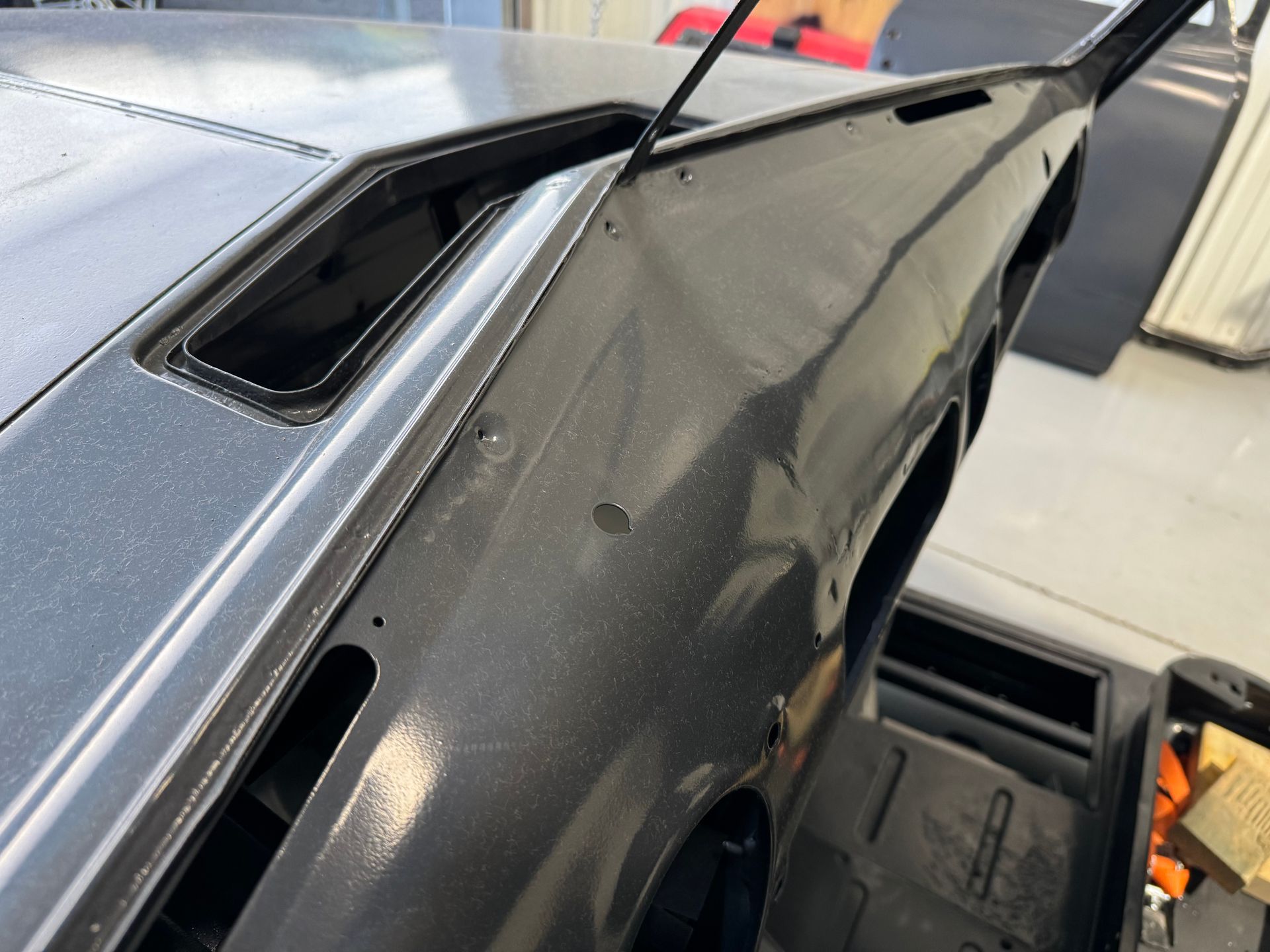 A black car is being worked on in a garage