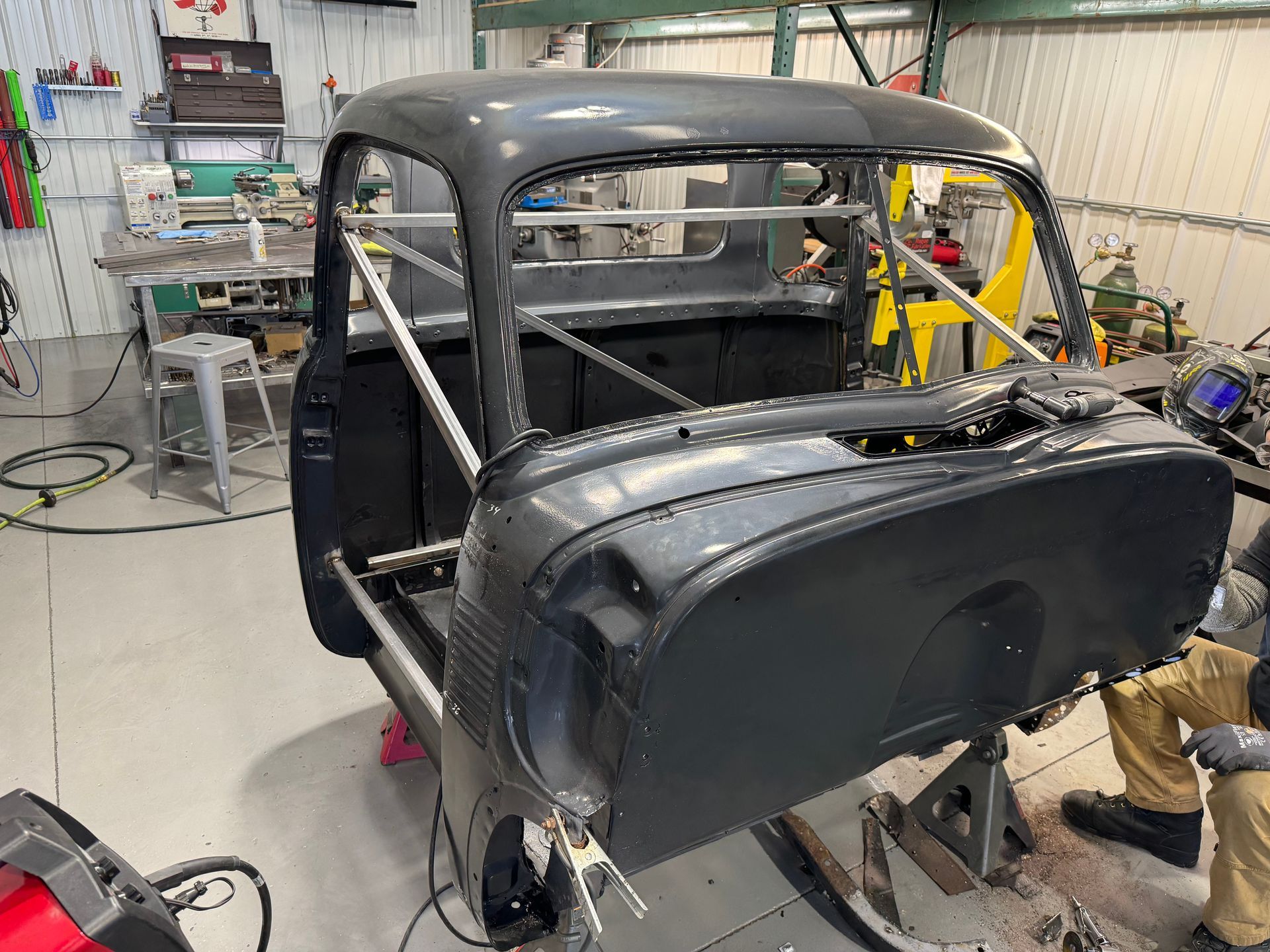 A black car is being built in a garage.