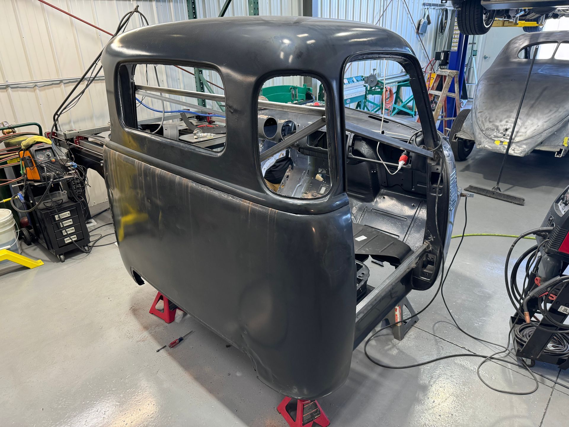 A black truck is being built in a garage.