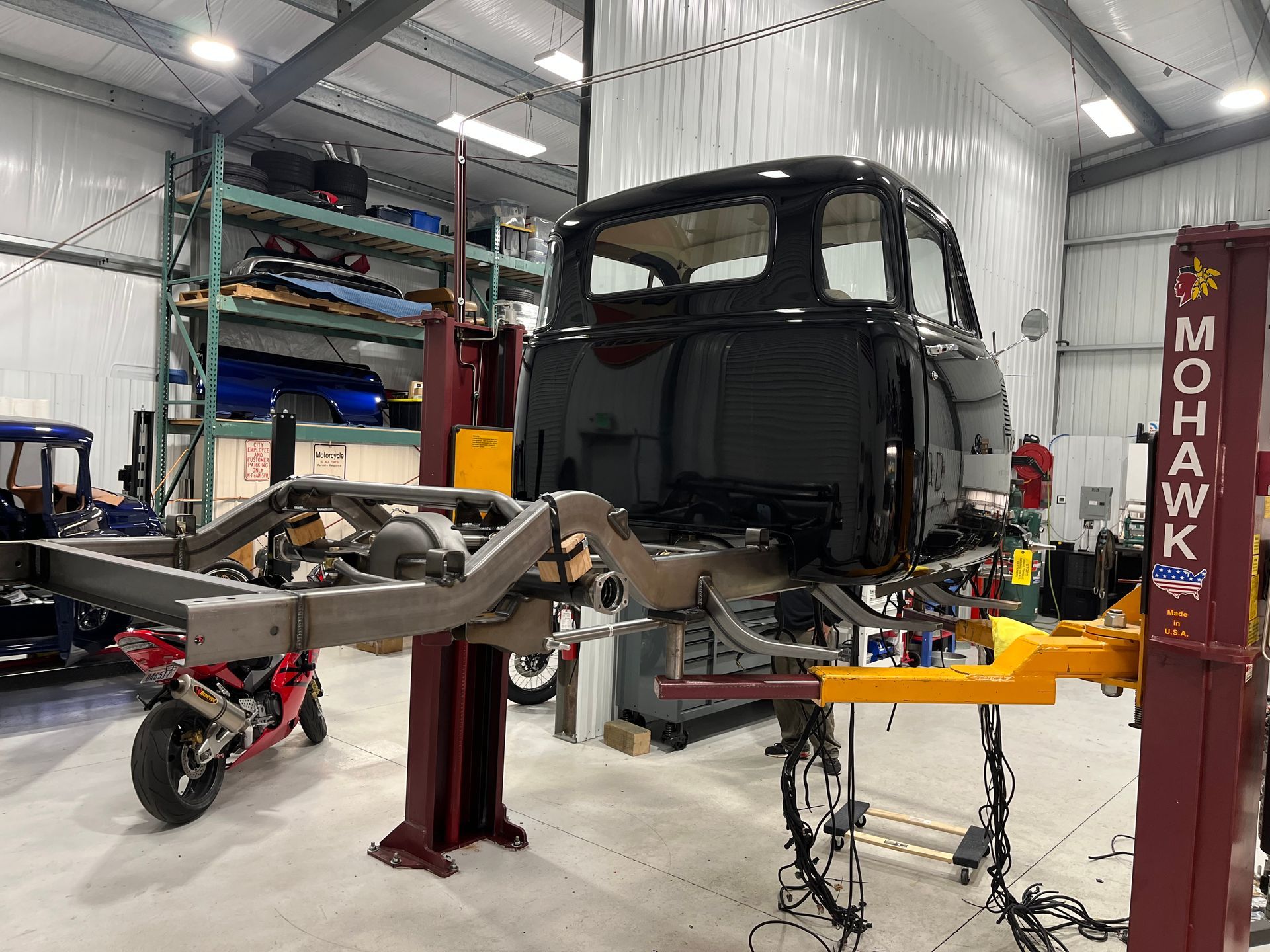 A truck is sitting on a lift in a garage.