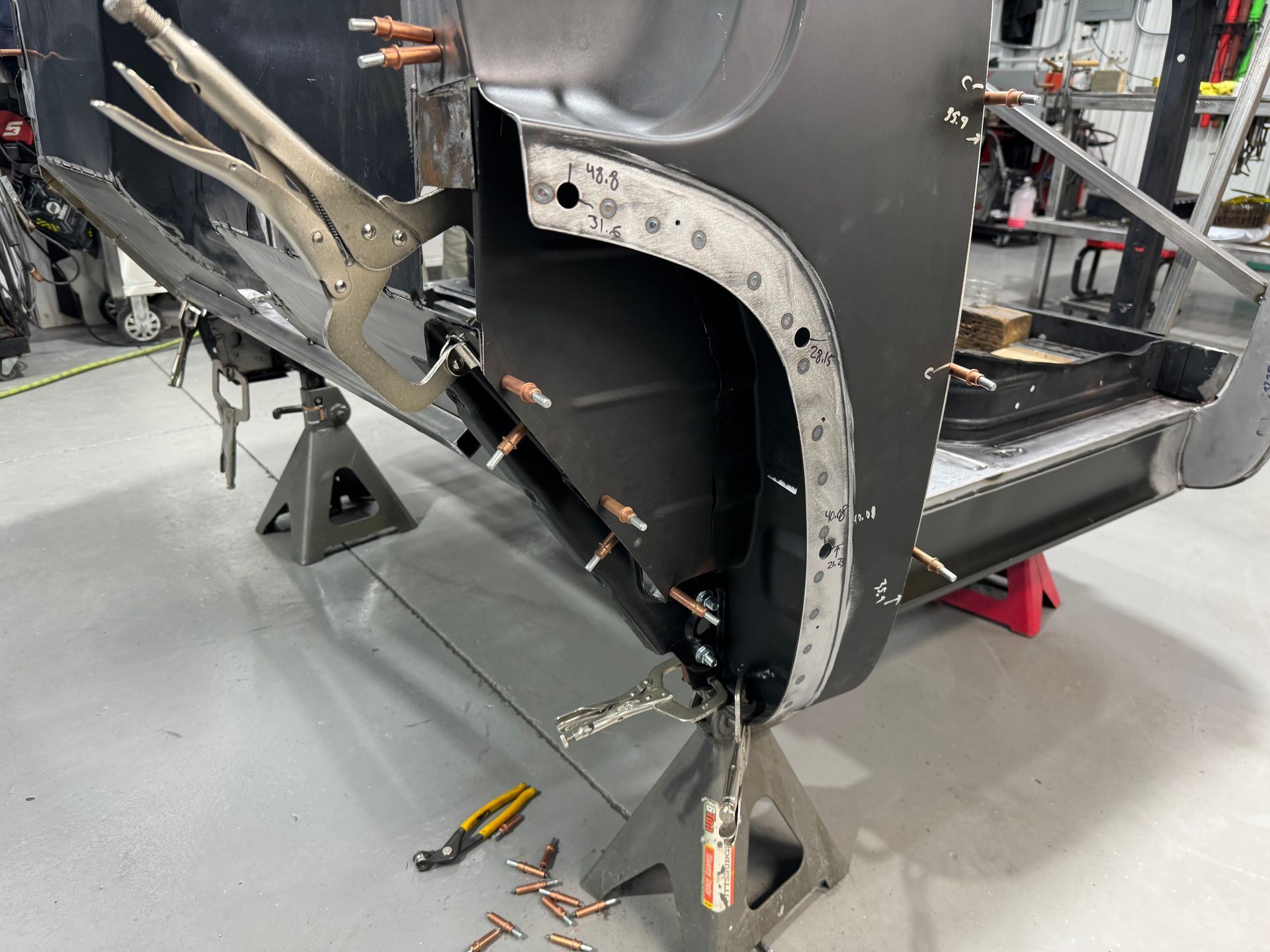 A piece of metal is being worked on in a garage.