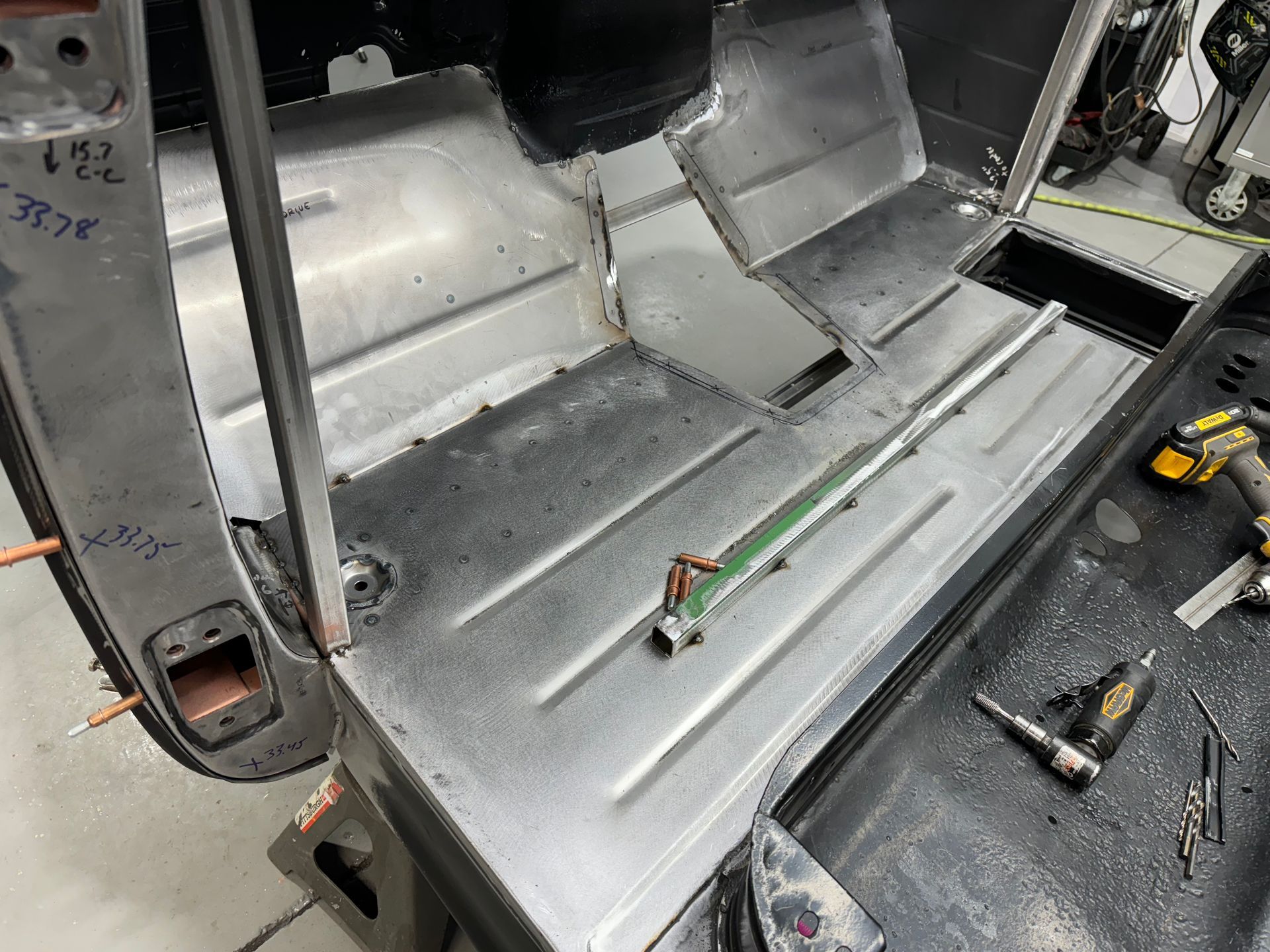 A car is being worked on in a garage with tools.