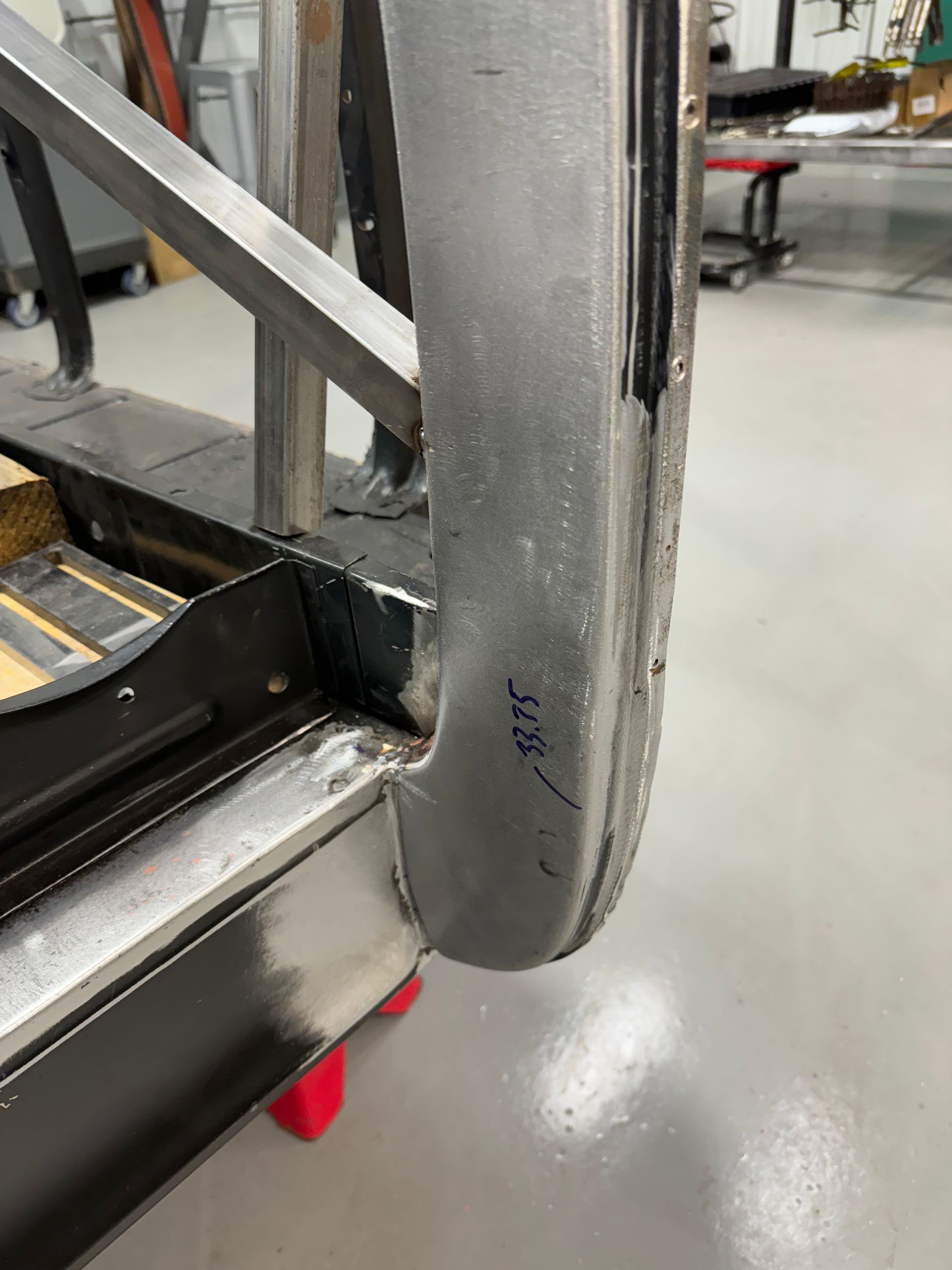 A piece of metal is sitting on a concrete floor in a room.