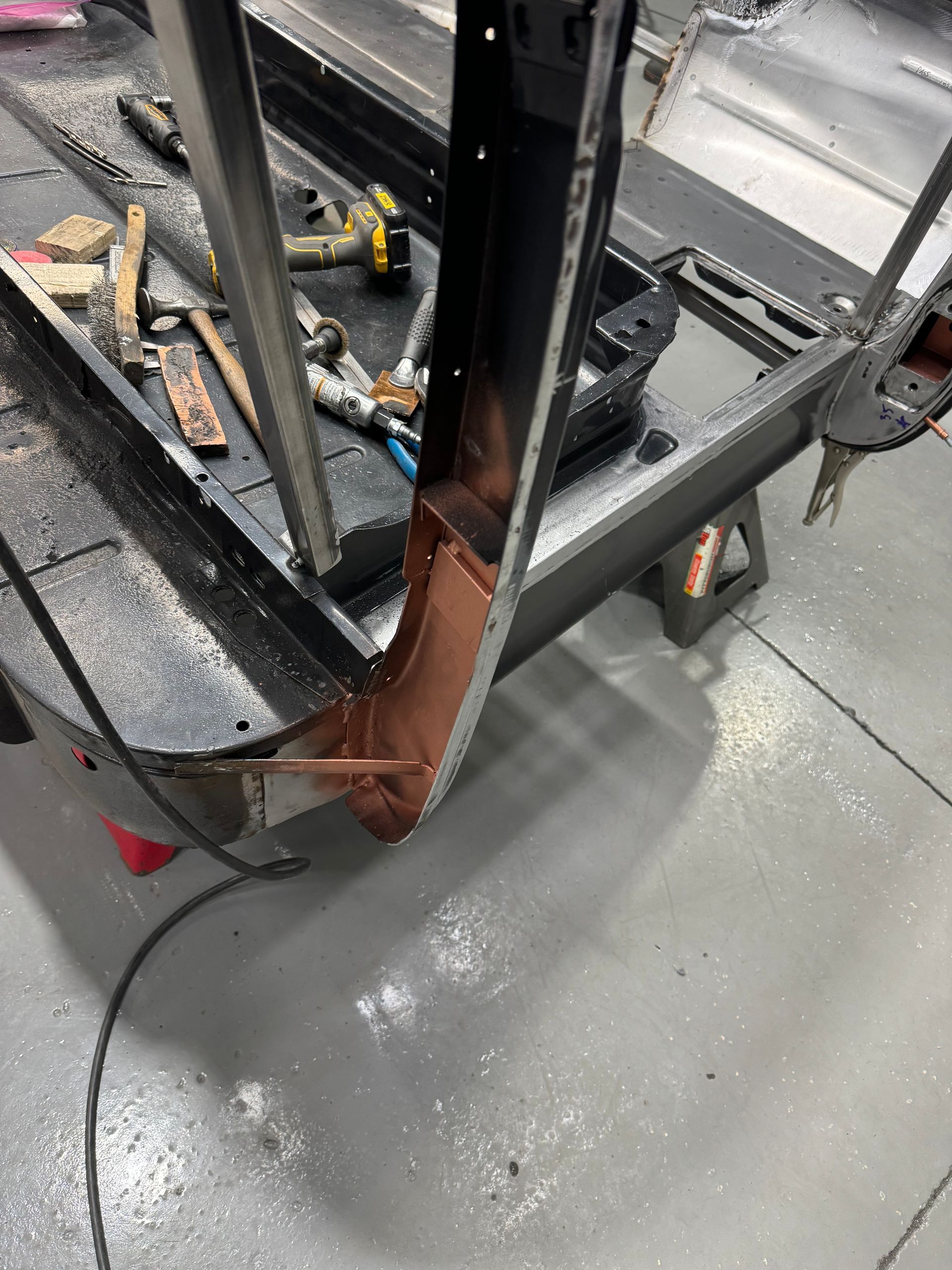 A piece of metal is being worked on in a garage.