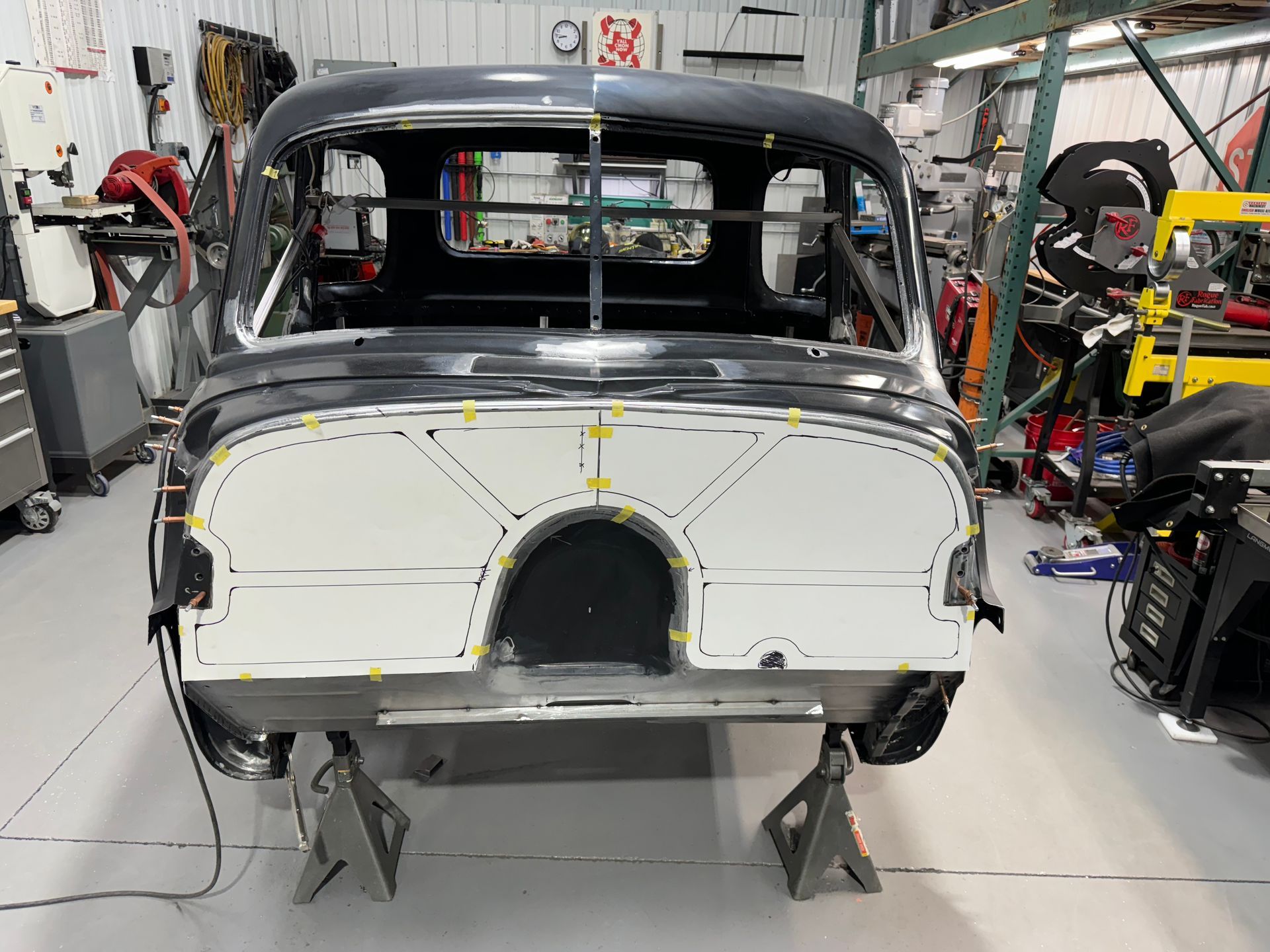 A black car is being built in a garage