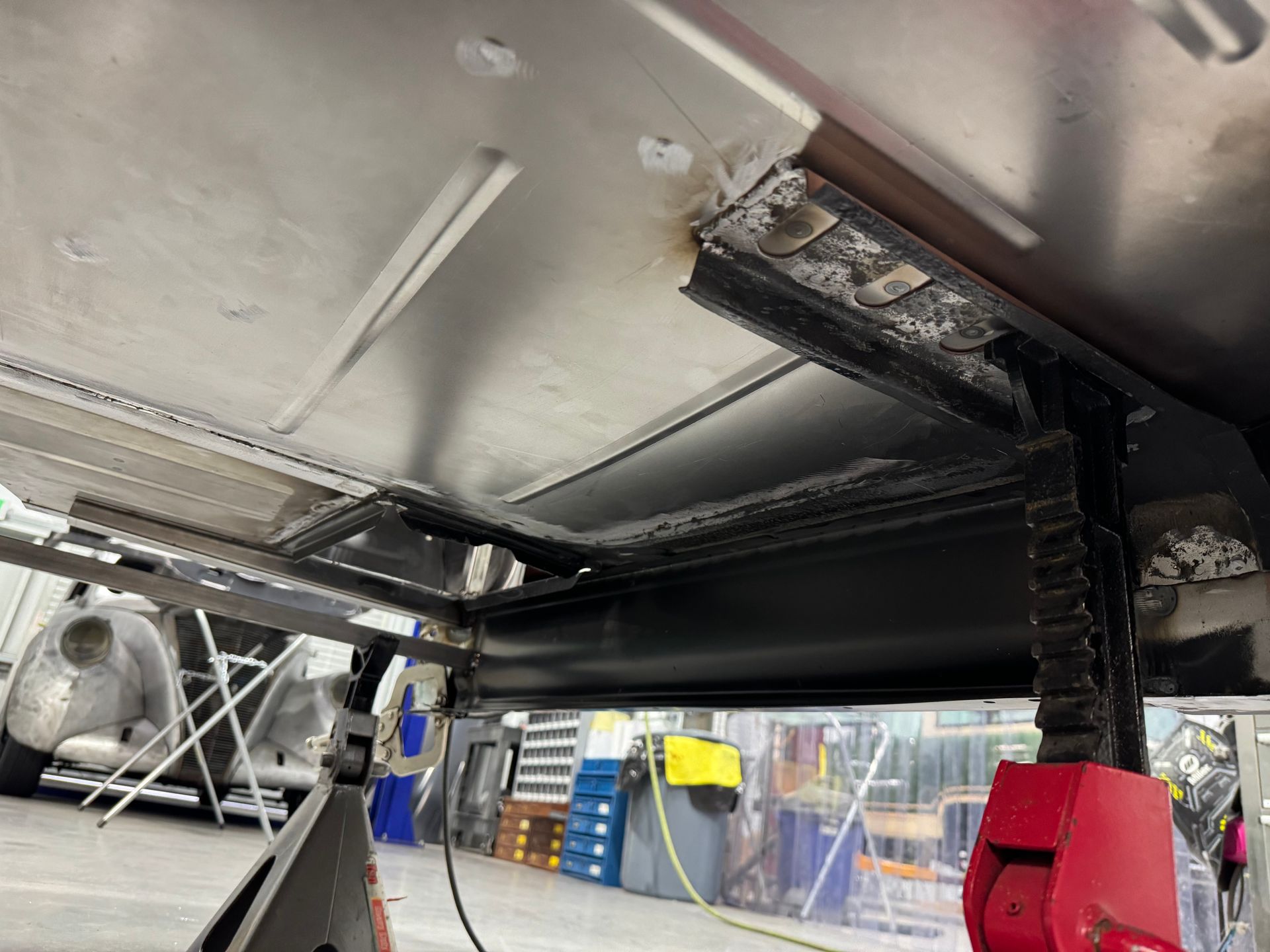A close up of a metal structure in a garage with a red object in the foreground.