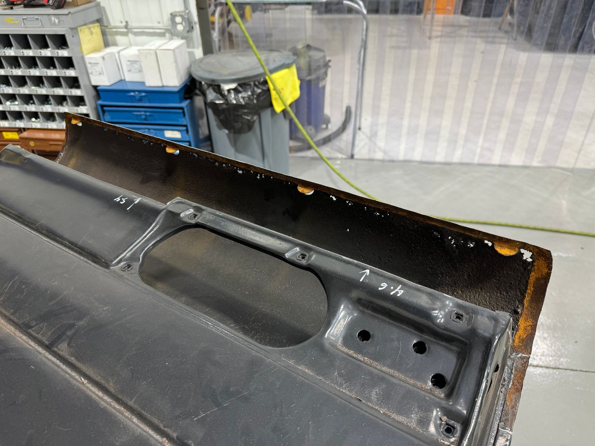 A piece of metal is sitting on the floor in a garage.