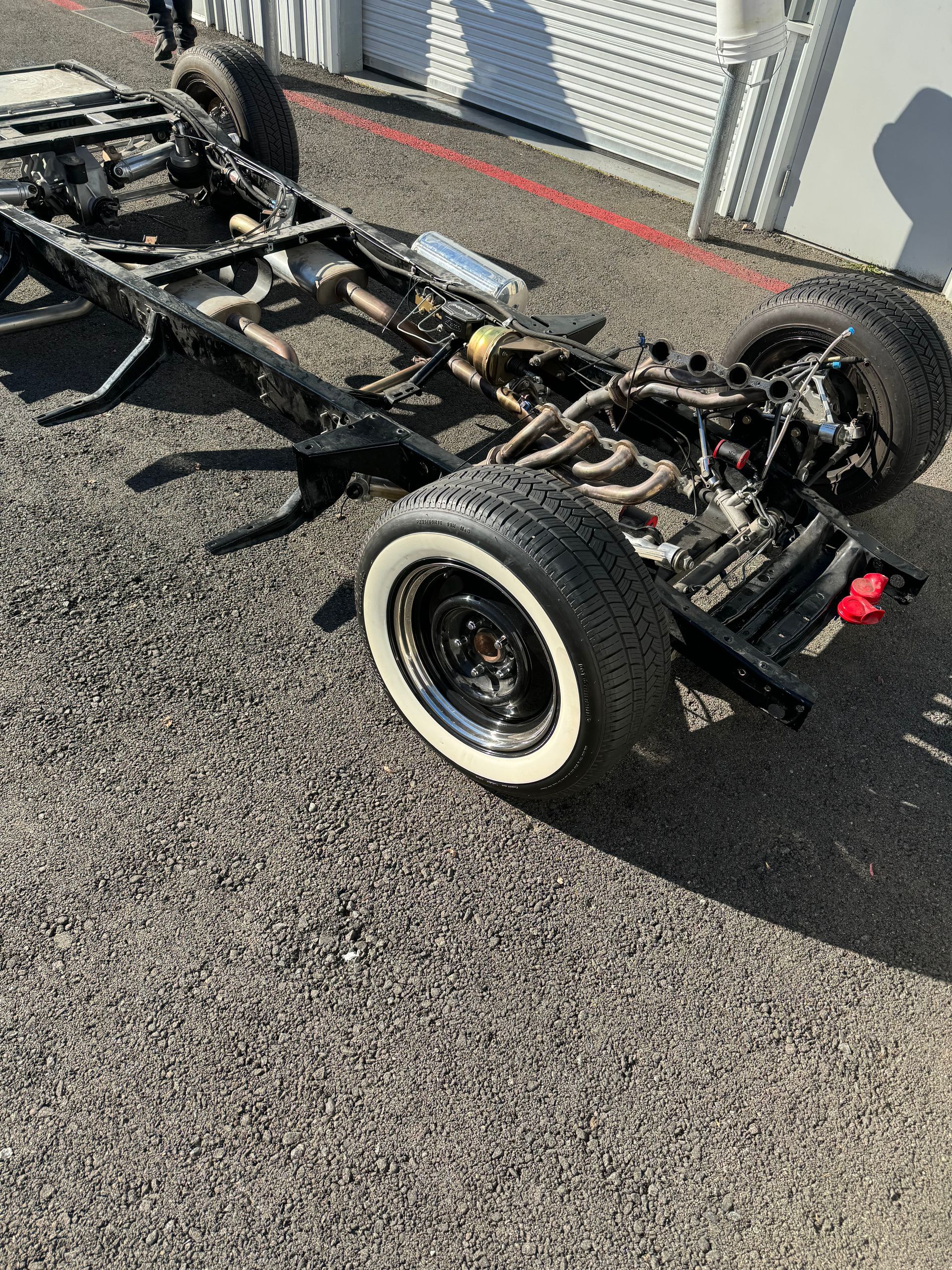 A truck chassis is sitting on the side of the road.