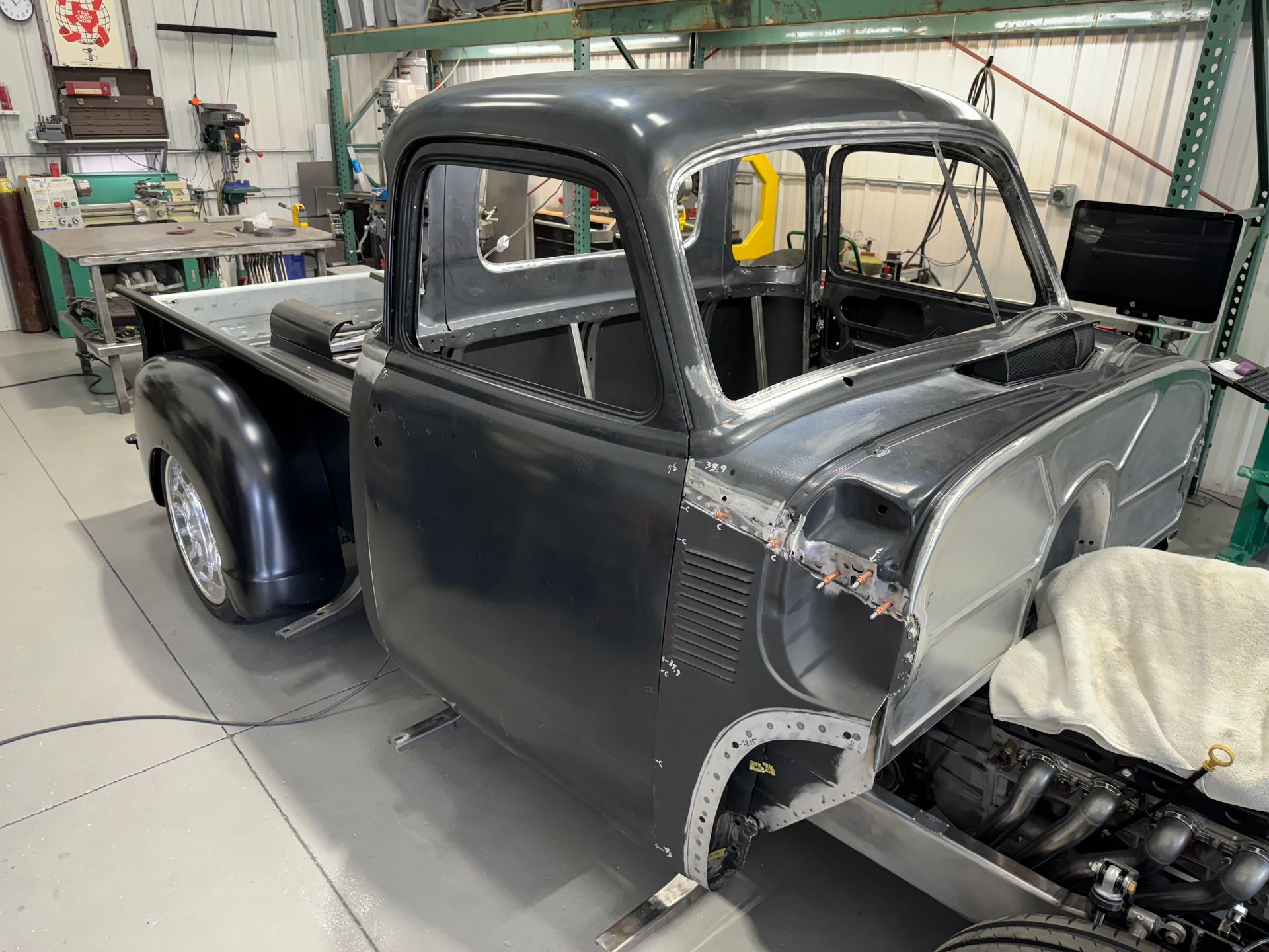 A black truck is being built in a garage.