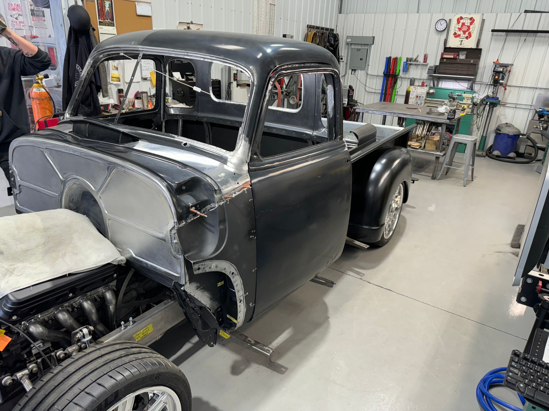 A black truck is being built in a garage.