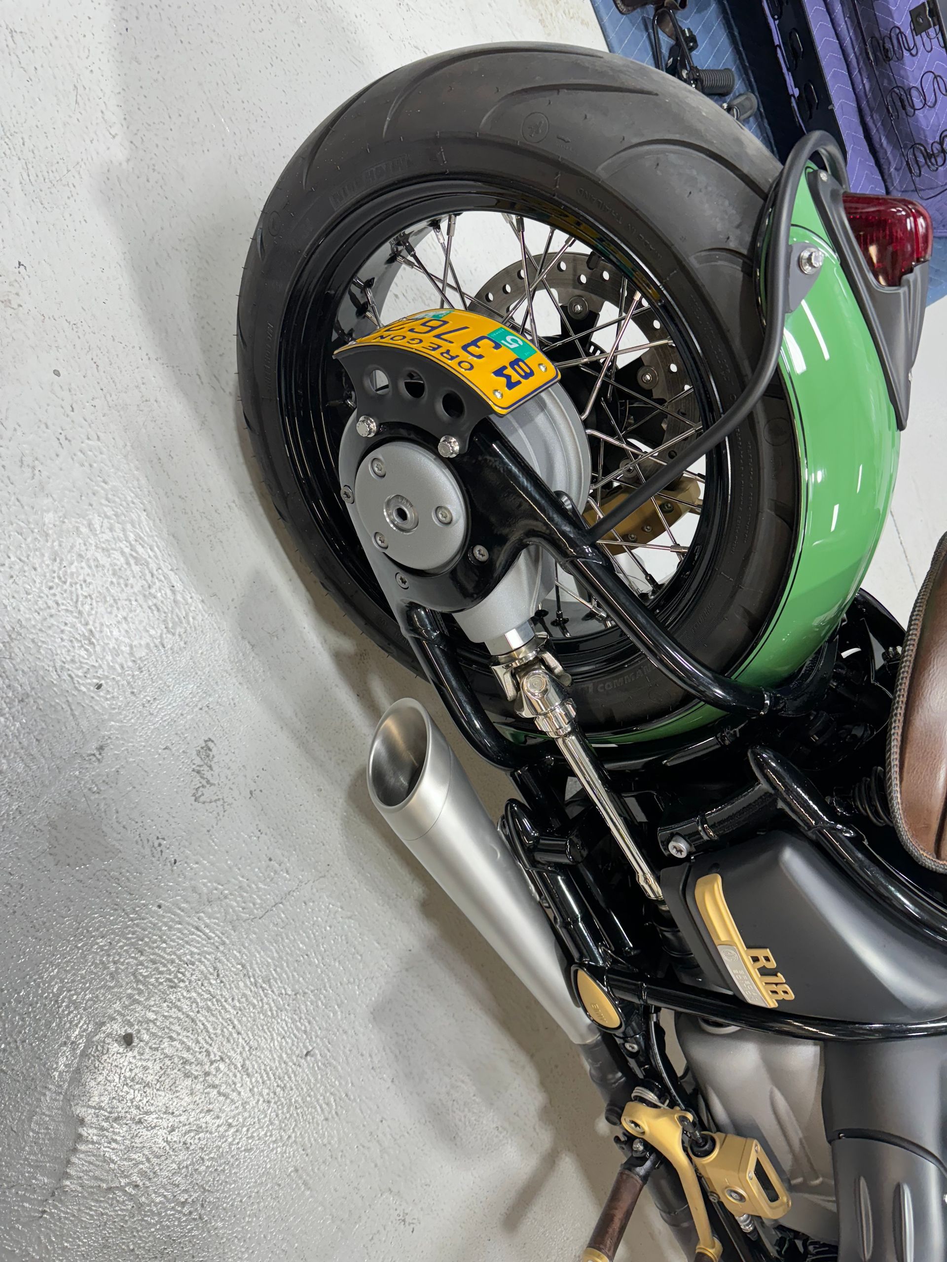 A close up of a motorcycle 's rear wheel with a license plate on it