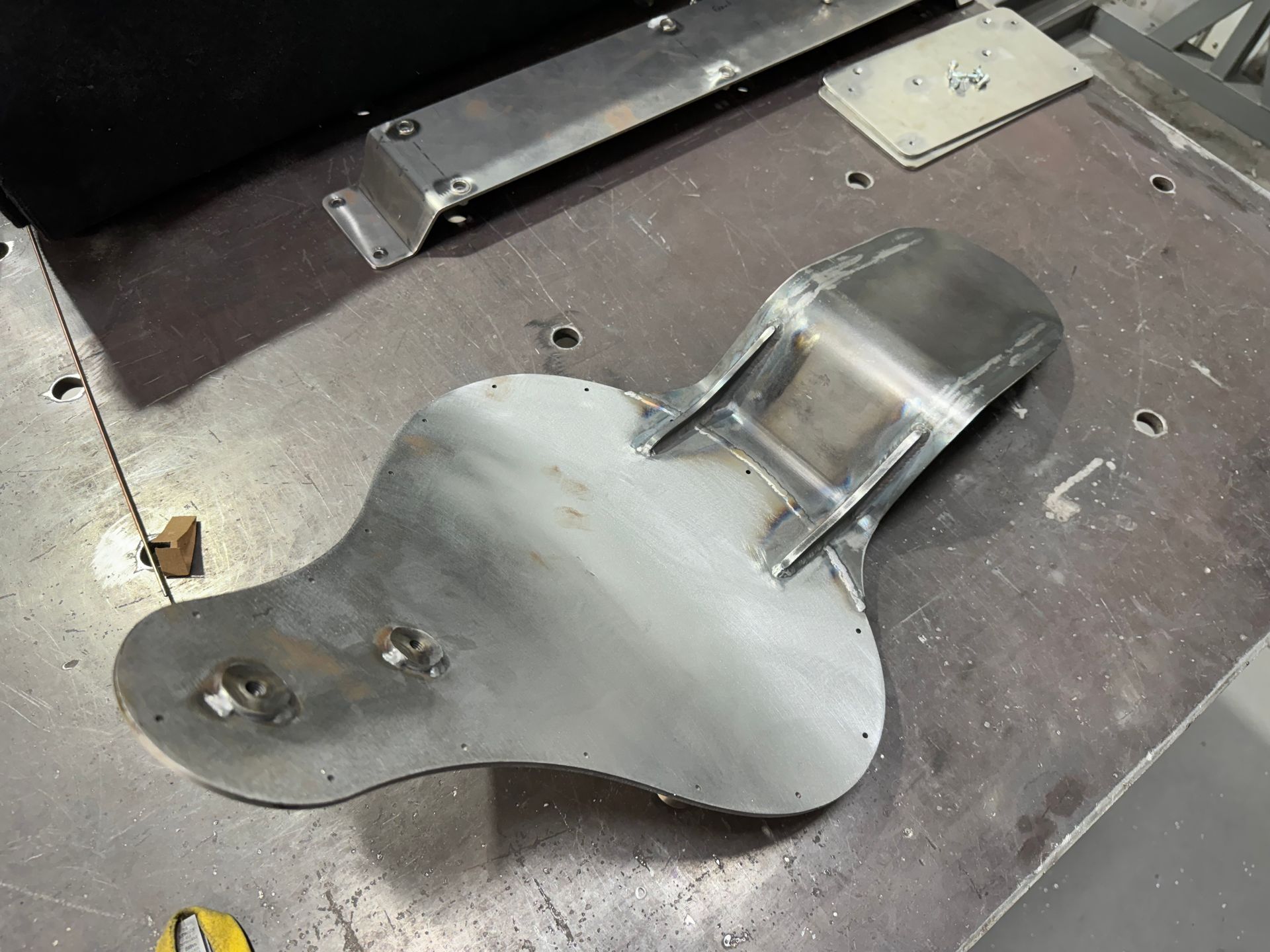 A piece of metal is sitting on top of a metal table.