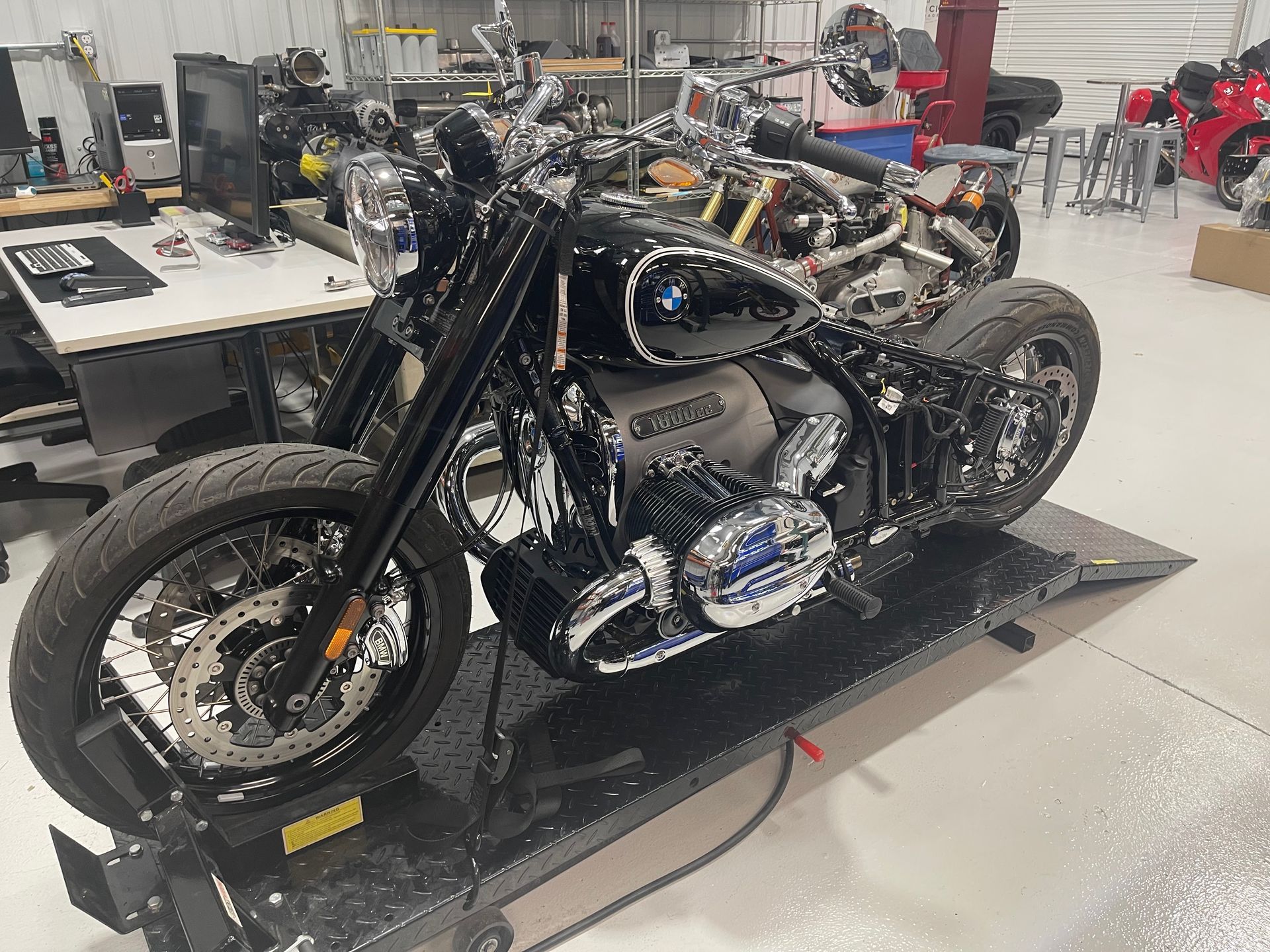 A motorcycle is sitting on a lift in a garage.